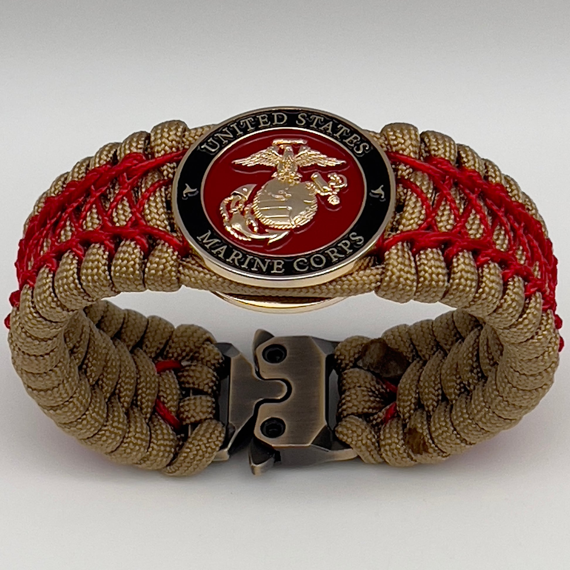 Thick, wide, rigid and comfortable braided United States Marine Corps bracelet featuring a 24K gold plated USMC Eagle Globe and Anchor medallion, a gold Cobra style tactical buckle and woven with gold 550 paracord and Imperial Red nano and micro cord.
