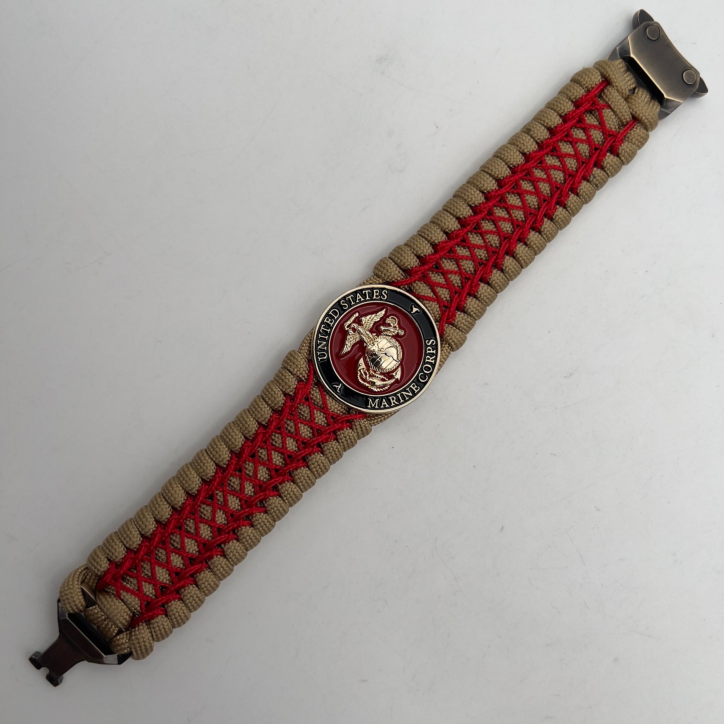 Thick, wide, rigid and comfortable braided United States Marine Corps bracelet featuring a 24K gold plated USMC Eagle Globe and Anchor medallion, a gold Cobra style tactical buckle and woven with gold 550 paracord and Imperial Red nano and micro cord.