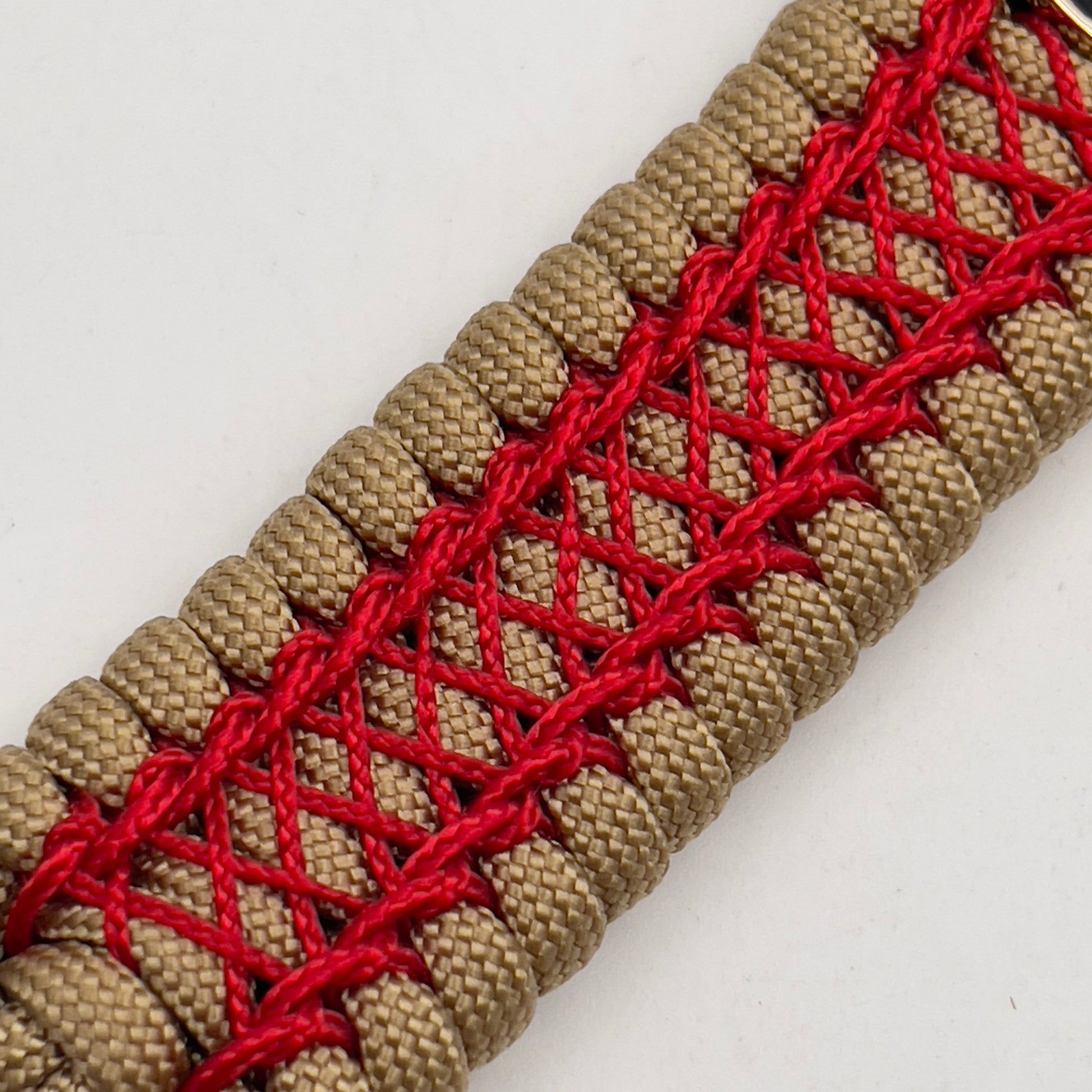 Thick, wide, rigid and comfortable braided United States Marine Corps bracelet featuring a 24K gold plated USMC Eagle Globe and Anchor medallion, a gold Cobra style tactical buckle and woven with gold 550 paracord and Imperial Red nano and micro cord.