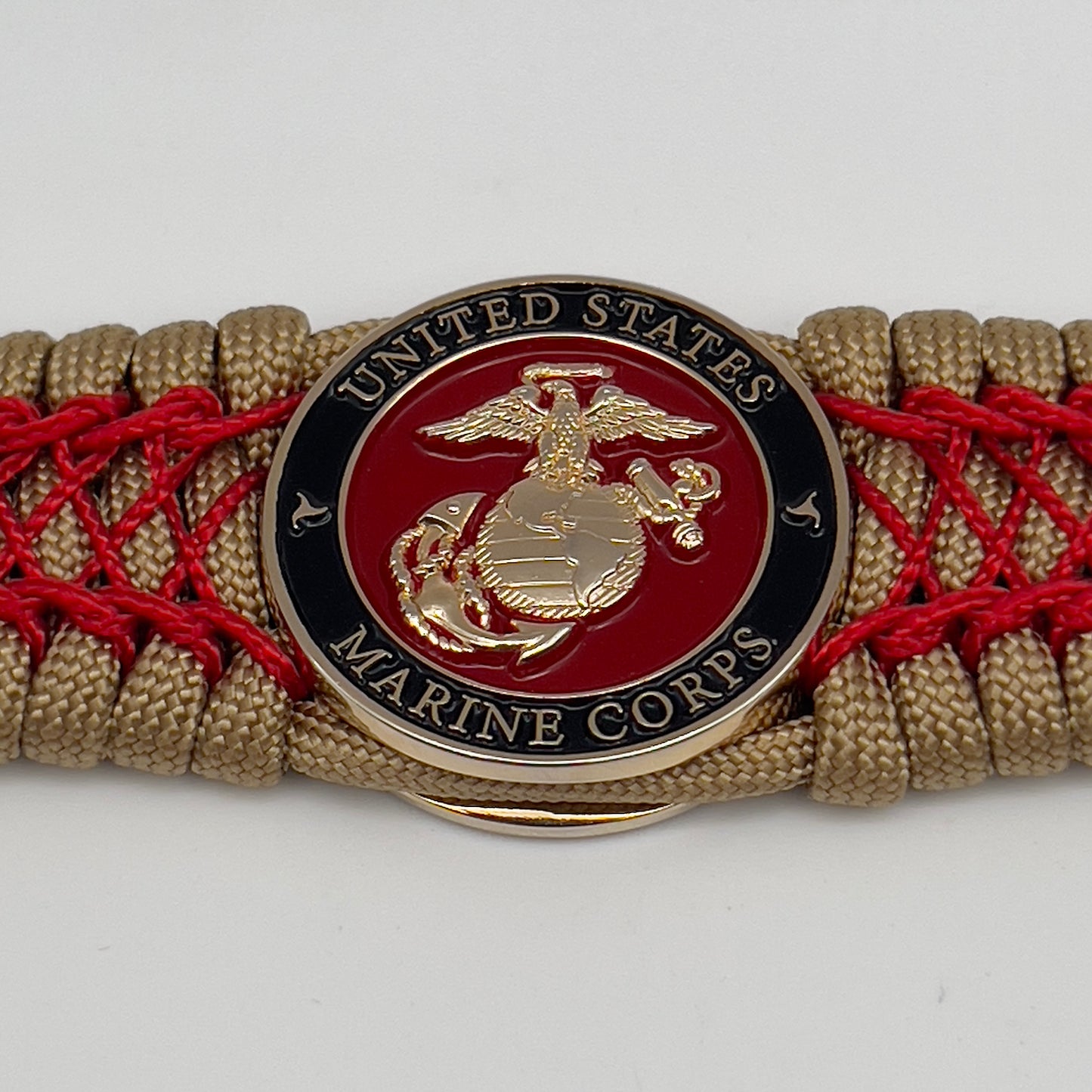 Thick, wide, rigid and comfortable braided United States Marine Corps bracelet featuring a 24K gold plated USMC Eagle Globe and Anchor medallion, a gold Cobra style tactical buckle and woven with gold 550 paracord and Imperial Red nano and micro cord.