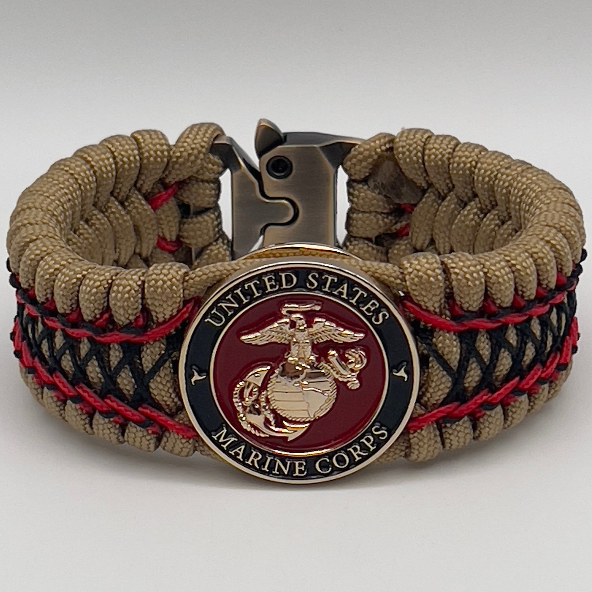 Thick, wide, rigid and comfortable braided United States Marine Corps bracelet featuring a 24K gold plated USMC Eagle Globe and Anchor medallion, a gold Cobra style tactical buckle and woven with gold 550 paracord and Imperial Red micro and black nano cord.