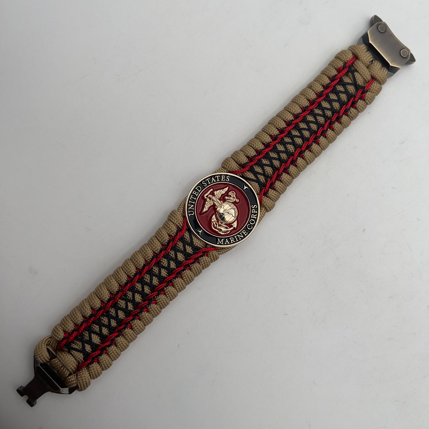 Thick, wide, rigid and comfortable braided United States Marine Corps bracelet featuring a 24K gold plated USMC Eagle Globe and Anchor medallion, a gold Cobra style tactical buckle and woven with gold 550 paracord and Imperial Red micro and black nano cord.