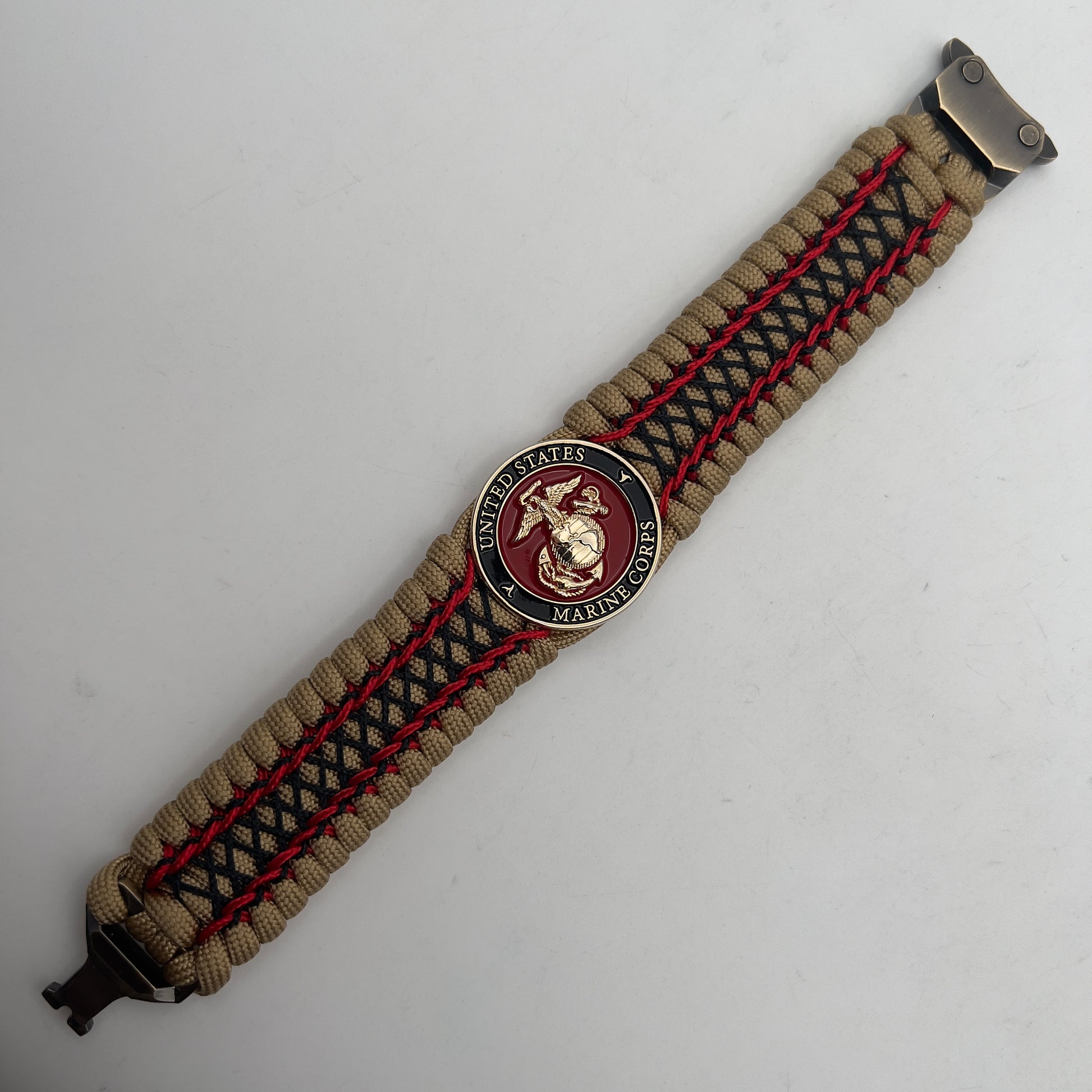 Thick, wide, rigid and comfortable braided United States Marine Corps bracelet featuring a 24K gold plated USMC Eagle Globe and Anchor medallion, a gold Cobra style tactical buckle and woven with gold 550 paracord and Imperial Red micro and black nano cord.