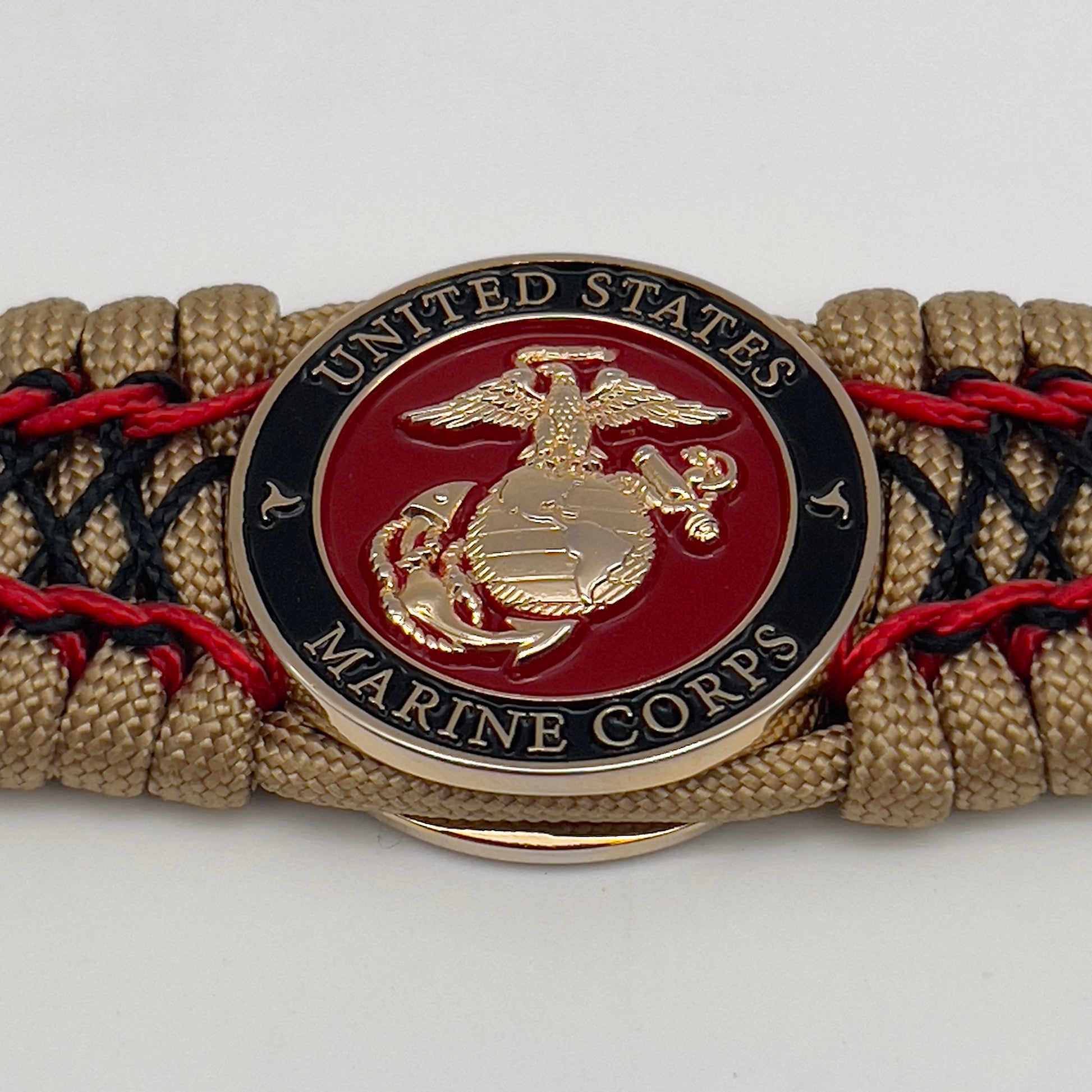 Thick, wide, rigid and comfortable braided United States Marine Corps bracelet featuring a 24K gold plated USMC Eagle Globe and Anchor medallion, a gold Cobra style tactical buckle and woven with gold 550 paracord and Imperial Red micro and black nano cord.