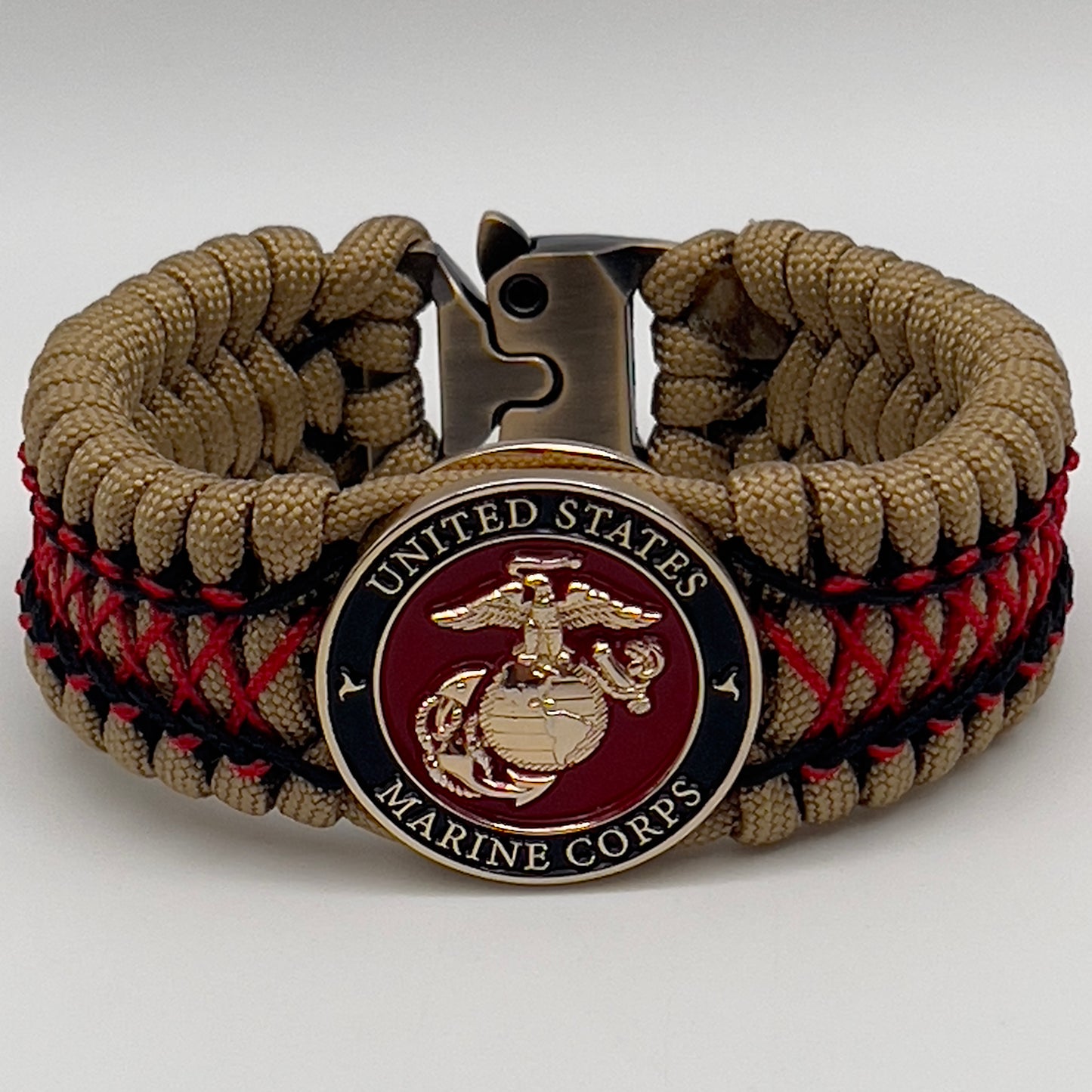Thick, wide, rigid and comfortable braided United States Marine Corps bracelet featuring a 24K gold plated USMC Eagle Globe and Anchor medallion, a gold Cobra style tactical buckle and woven with gold 550 paracord and Imperial Red micro and black nano cord.