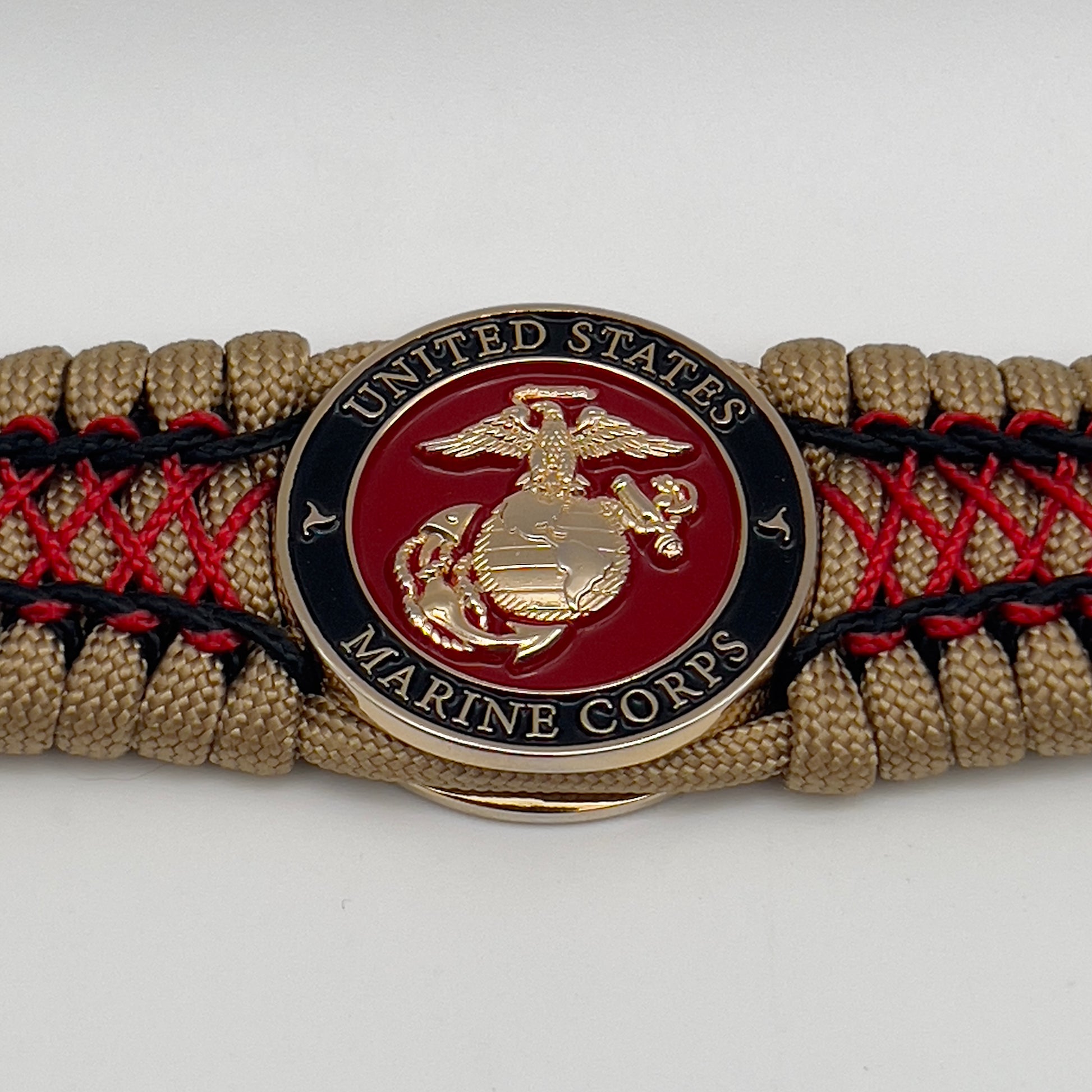 Thick, wide, rigid and comfortable braided United States Marine Corps bracelet featuring a 24K gold plated USMC Eagle Globe and Anchor medallion, a gold Cobra style tactical buckle and woven with gold 550 paracord and Imperial Red micro and black nano cord.