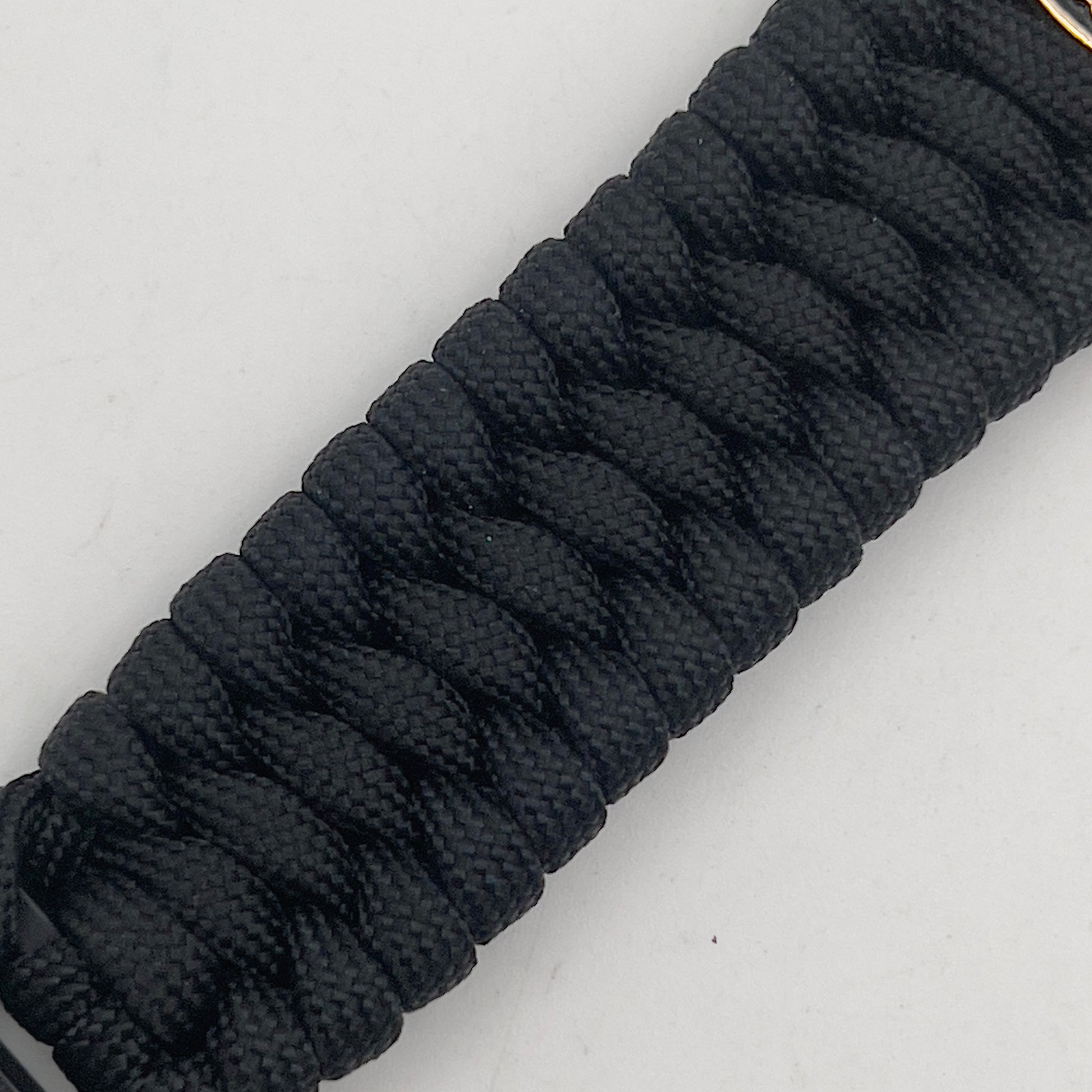Thick, wide, rigid and comfortable braided United States Marine Corps bracelet featuring a 24K gold plated USMC Eagle Globe and Anchor medallion, a black Cobra style tactical buckle and woven with black 550 paracord.