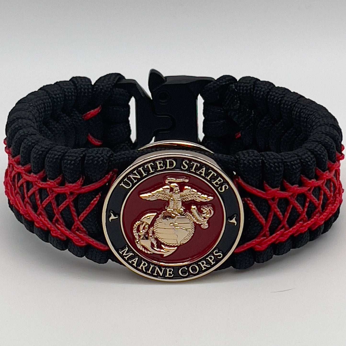 Thick, wide, rigid and comfortable braided United States Marine Corps bracelet featuring a 24K gold plated USMC Eagle Globe and Anchor medallion, a black Cobra style tactical buckle and woven with black 550 paracord and Imperial Red nano and micro cord.