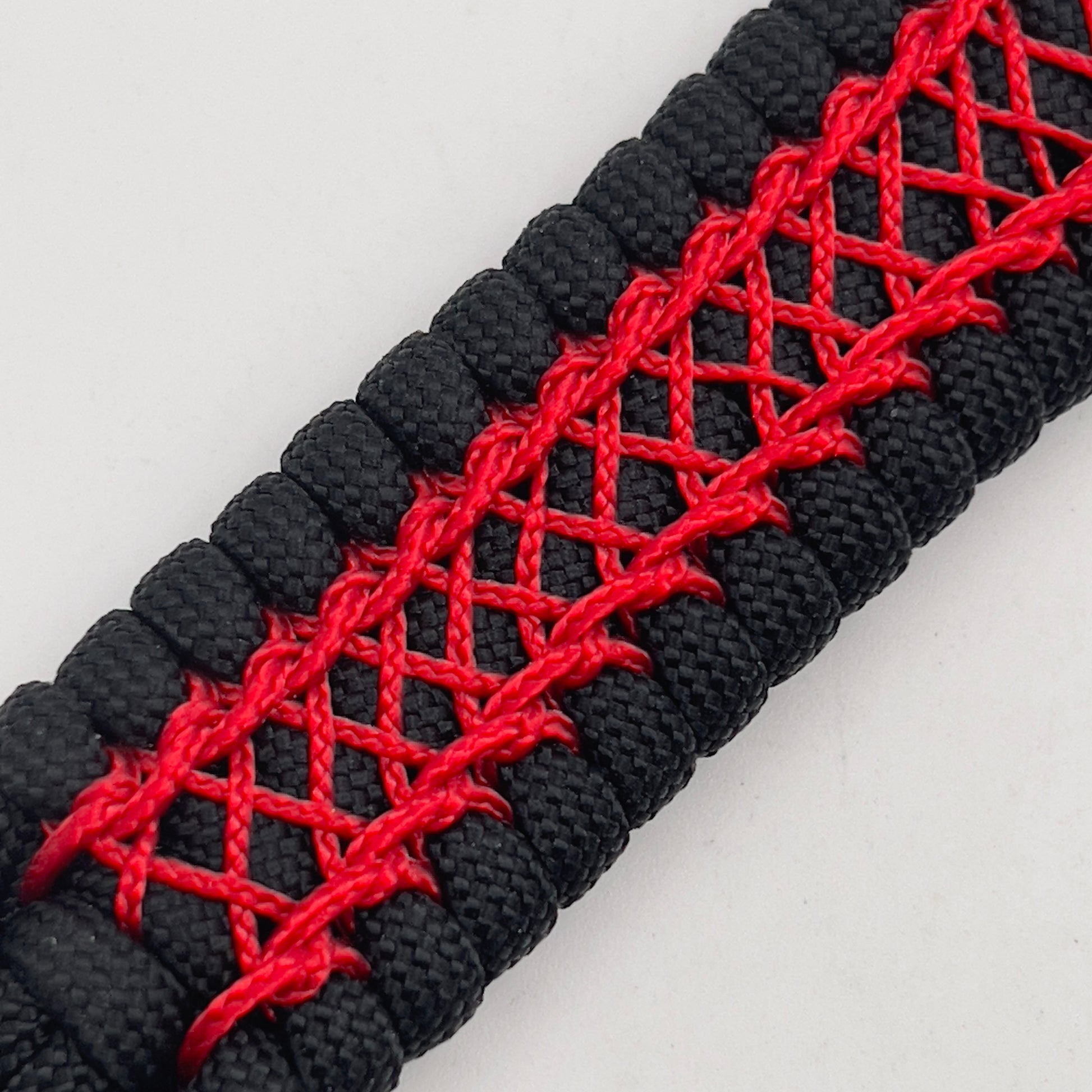 Thick, wide, rigid and comfortable braided United States Marine Corps bracelet featuring a 24K gold plated USMC Eagle Globe and Anchor medallion, a black Cobra style tactical buckle and woven with black 550 paracord and Imperial Red nano and micro cord.