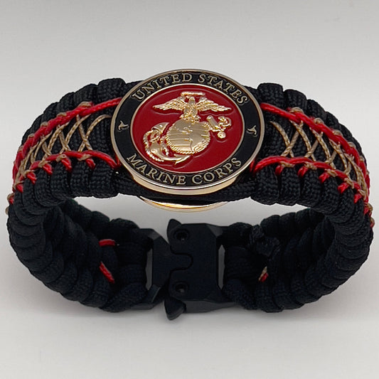 Thick, wide, rigid and comfortable braided United States Marine Corps bracelet featuring a 24K gold plated USMC Eagle Globe and Anchor medallion, a black Cobra style tactical buckle and woven with black 550 paracord and Imperial Red micro and gold nano cord.