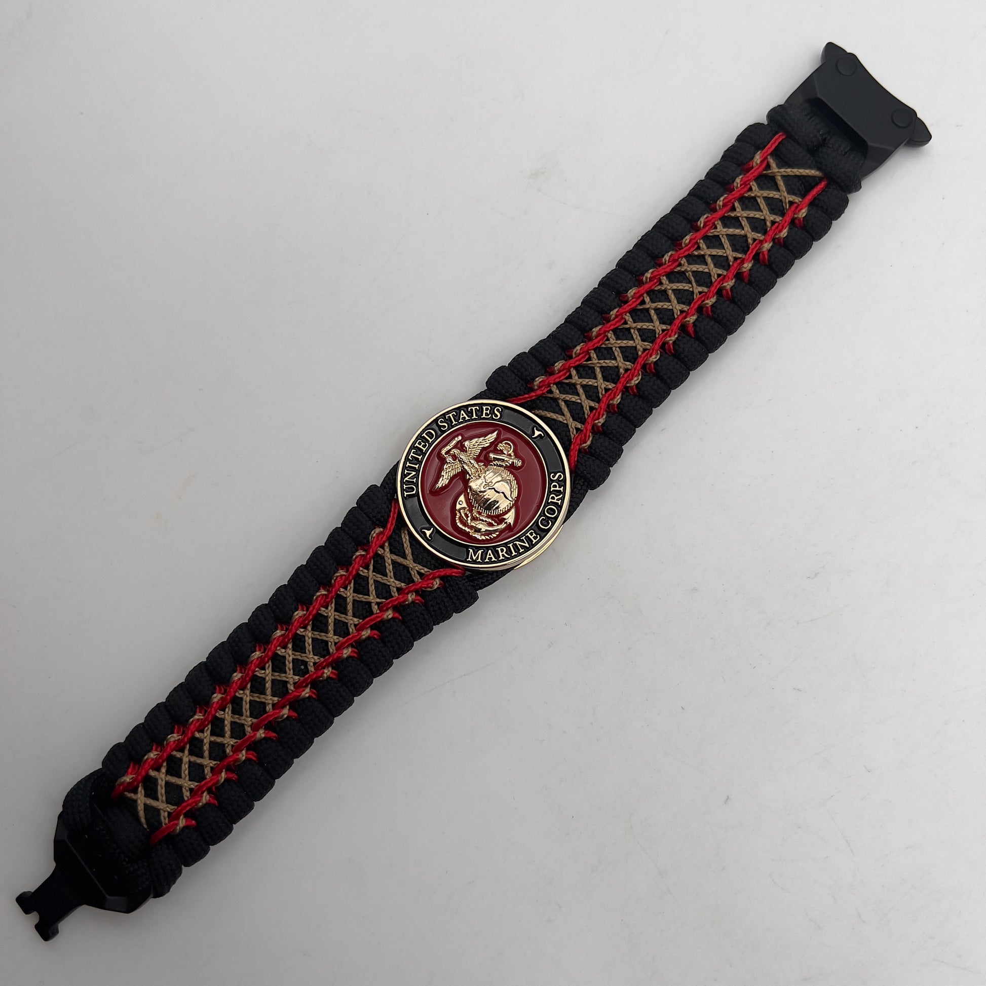 Thick, wide, rigid and comfortable braided United States Marine Corps bracelet featuring a 24K gold plated USMC Eagle Globe and Anchor medallion, a black Cobra style tactical buckle and woven with black 550 paracord and Imperial Red micro and gold nano cord.