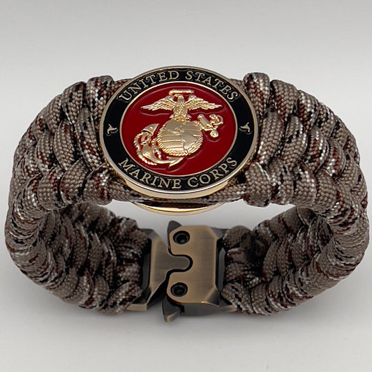 Thick, wide, semi-rigid and comfortable braided United States Marine Corps bracelet featuring a 24K gold plated USMC Eagle Globe and Anchor medallion, a gold Cobra style tactical buckle and woven with Desert Camo 550 paracord.