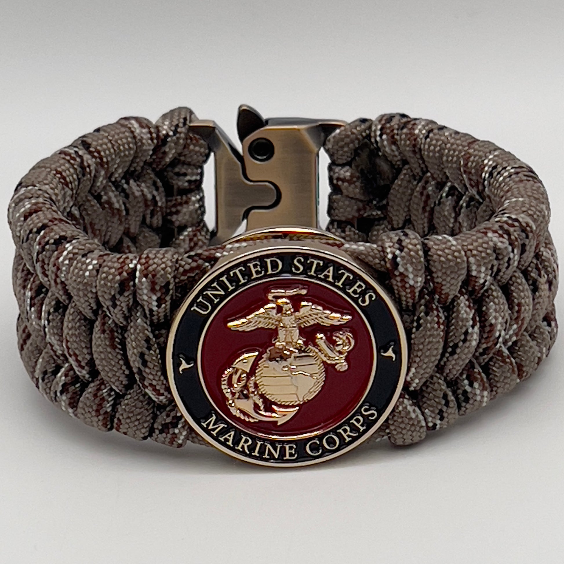 Thick, wide, semi-rigid and comfortable braided United States Marine Corps bracelet featuring a 24K gold plated USMC Eagle Globe and Anchor medallion, a gold Cobra style tactical buckle and woven with Desert Camo 550 paracord.