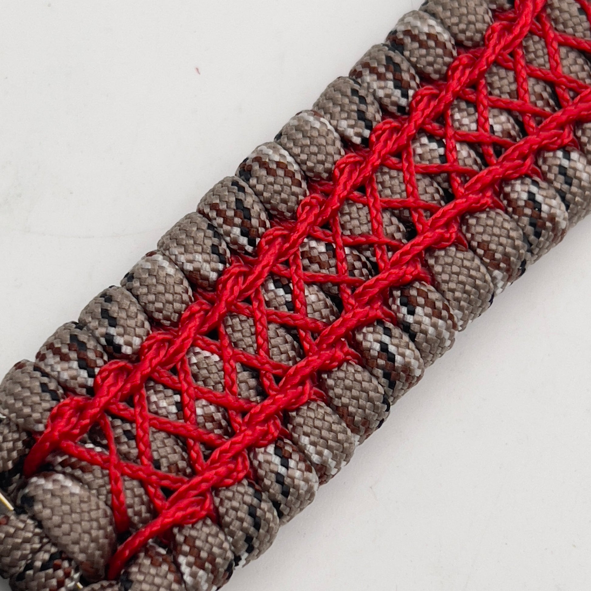 Thick, wide, rigid and comfortable braided United States Marine Corps bracelet featuring a 24K gold plated USMC Eagle Globe and Anchor medallion, a gold Cobra style tactical buckle and woven with Desert Camo 550 paracord and Imperial Red nano and micro cord.