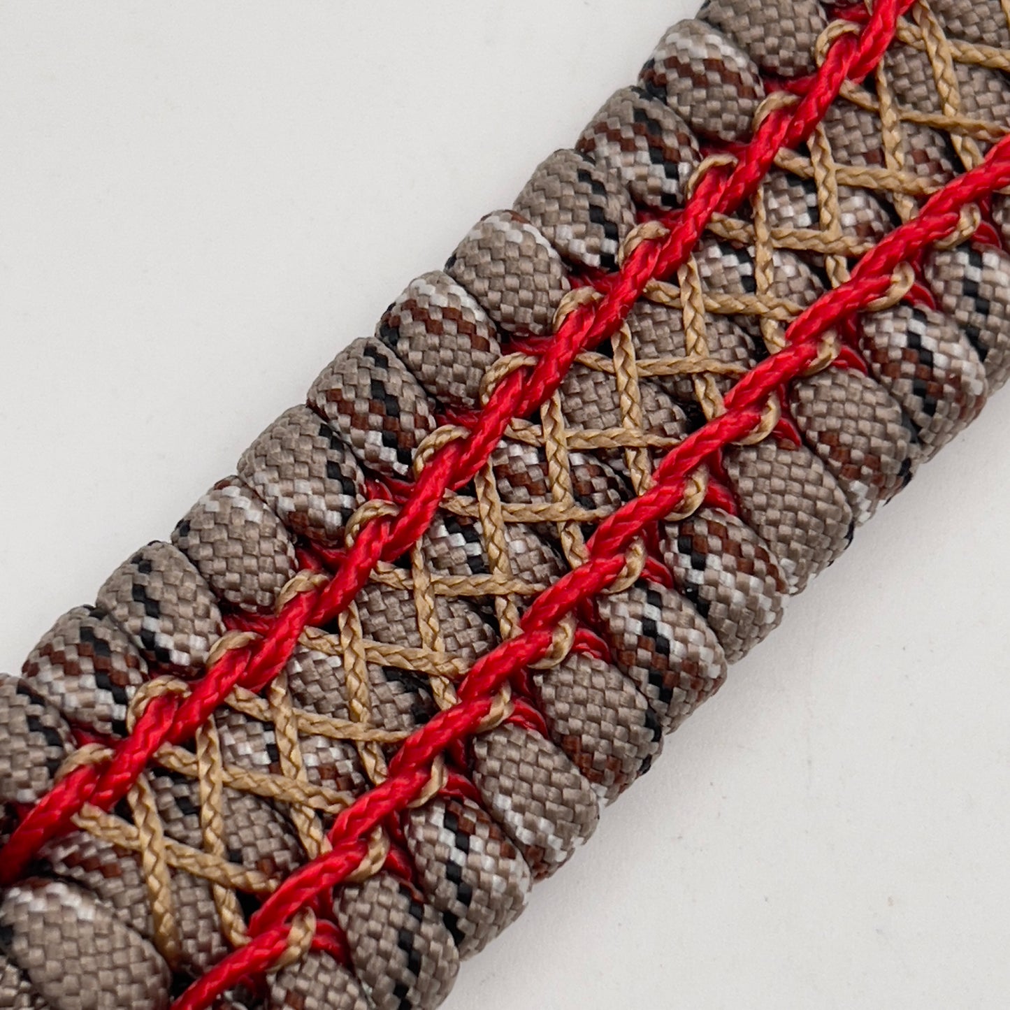 Thick, wide, rigid and comfortable braided United States Marine Corps bracelet featuring a 24K gold plated USMC Eagle Globe and Anchor medallion, a gold Cobra style tactical buckle and woven with Desert Camo 550 paracord and Imperial Red micro and gold nano cord.