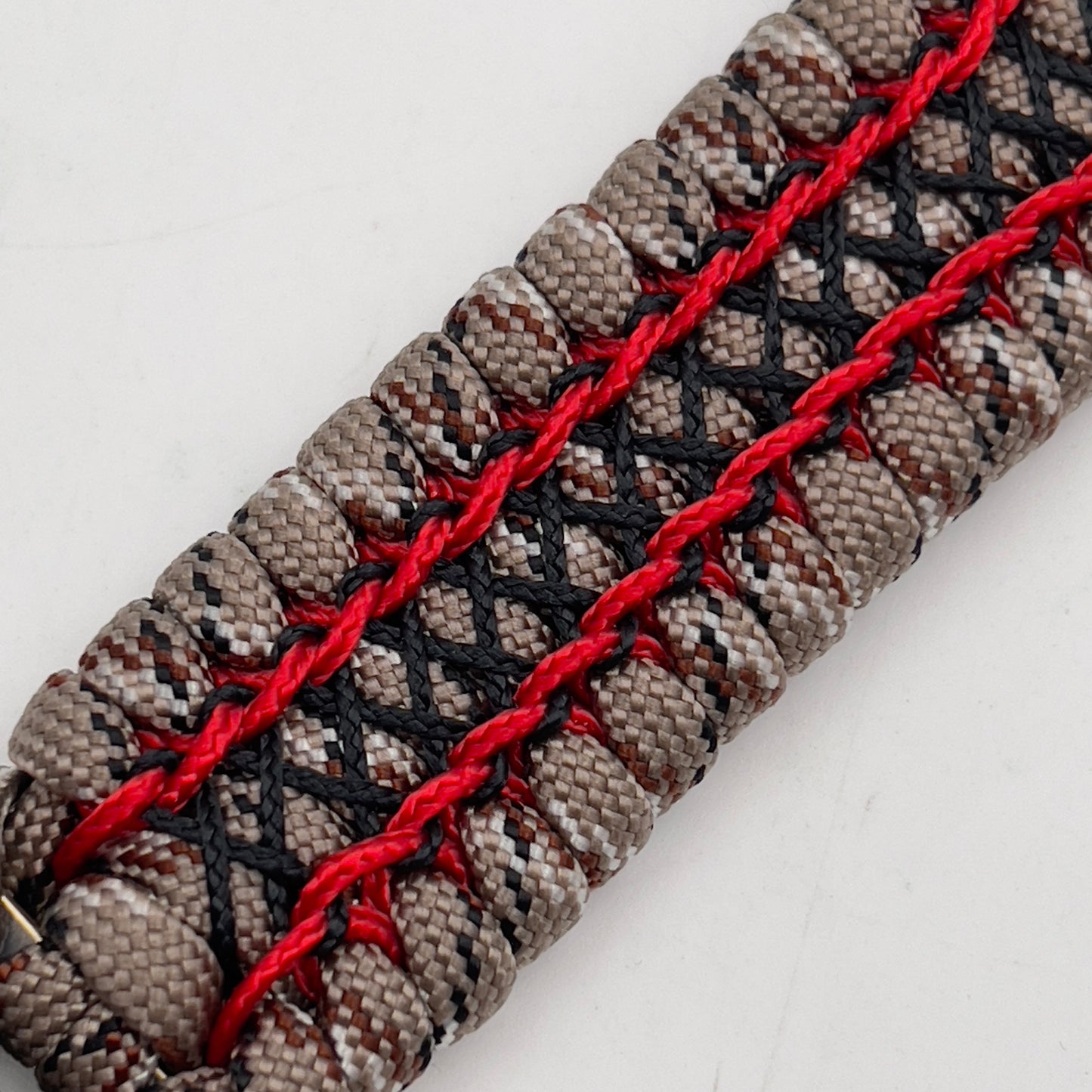 Thick, wide, rigid and comfortable braided United States Marine Corps bracelet featuring a 24K gold plated USMC Eagle Globe and Anchor medallion, a gold Cobra style tactical buckle and woven with Desert Camo 550 paracord, Imperial Red micro cord and black nano cord.