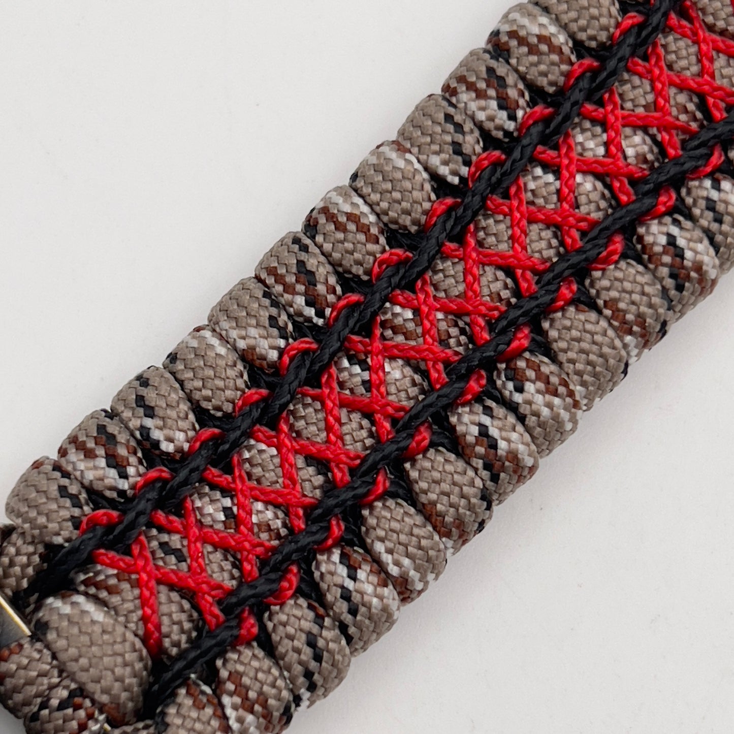 Thick, wide, rigid and comfortable braided United States Marine Corps bracelet featuring a 24K gold plated USMC Eagle Globe and Anchor medallion, a gold Cobra style tactical buckle and woven with Desert Camo 550 paracord, black micro cord and Imperial Red nano cord.