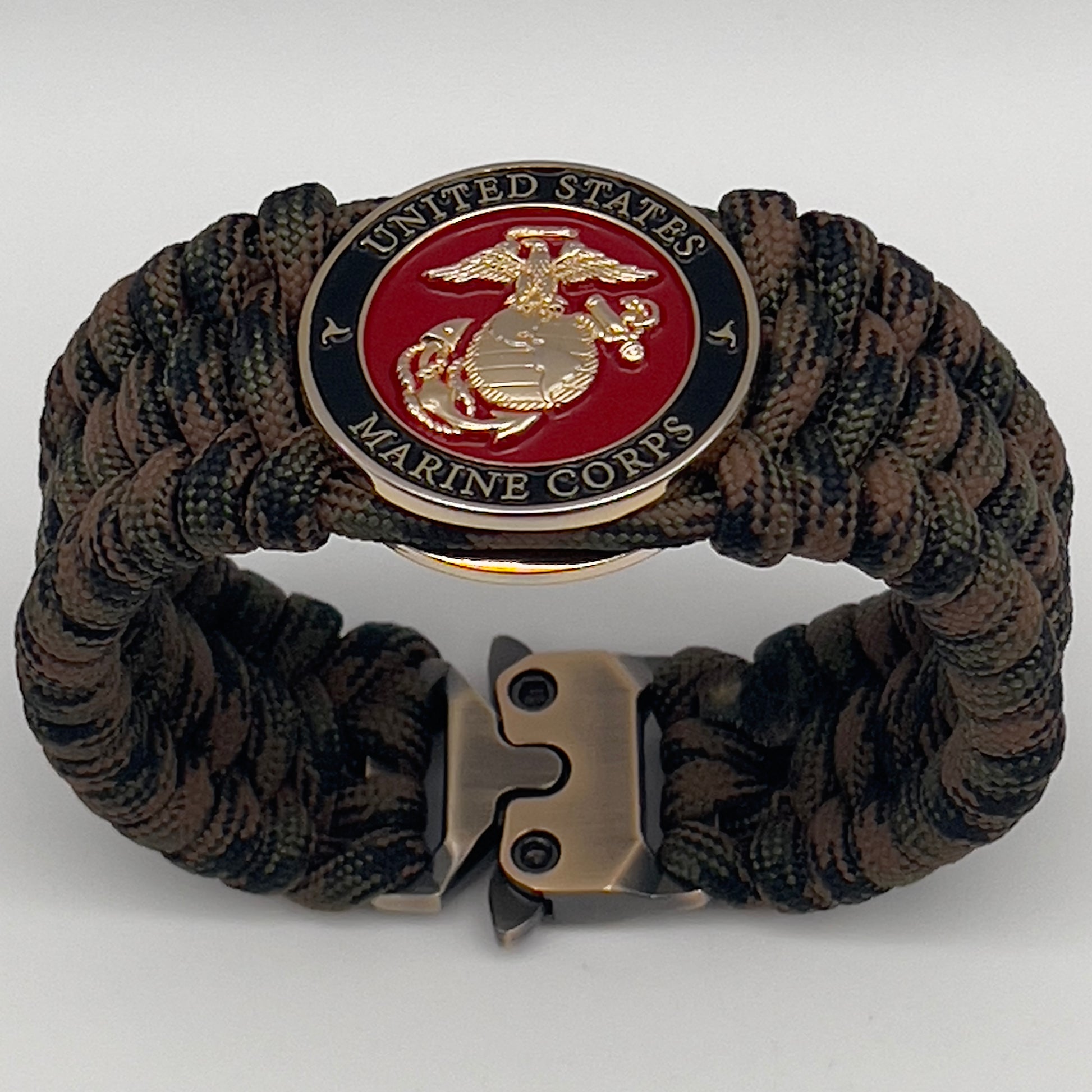 Thick, wide, semi-rigid and comfortable braided United States Marine Corps bracelet featuring a 24K gold plated USMC Eagle Globe and Anchor medallion, a gold Cobra style tactical buckle and woven with Woodland Camo 550 paracord.