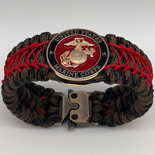 Thick, wide, rigid and comfortable braided United States Marine Corps bracelet featuring a 24K gold plated USMC Eagle Globe and Anchor medallion, a gold Cobra style tactical buckle and woven with Woodland Camo 550 paracord and Imperial Red nano and micro cord.