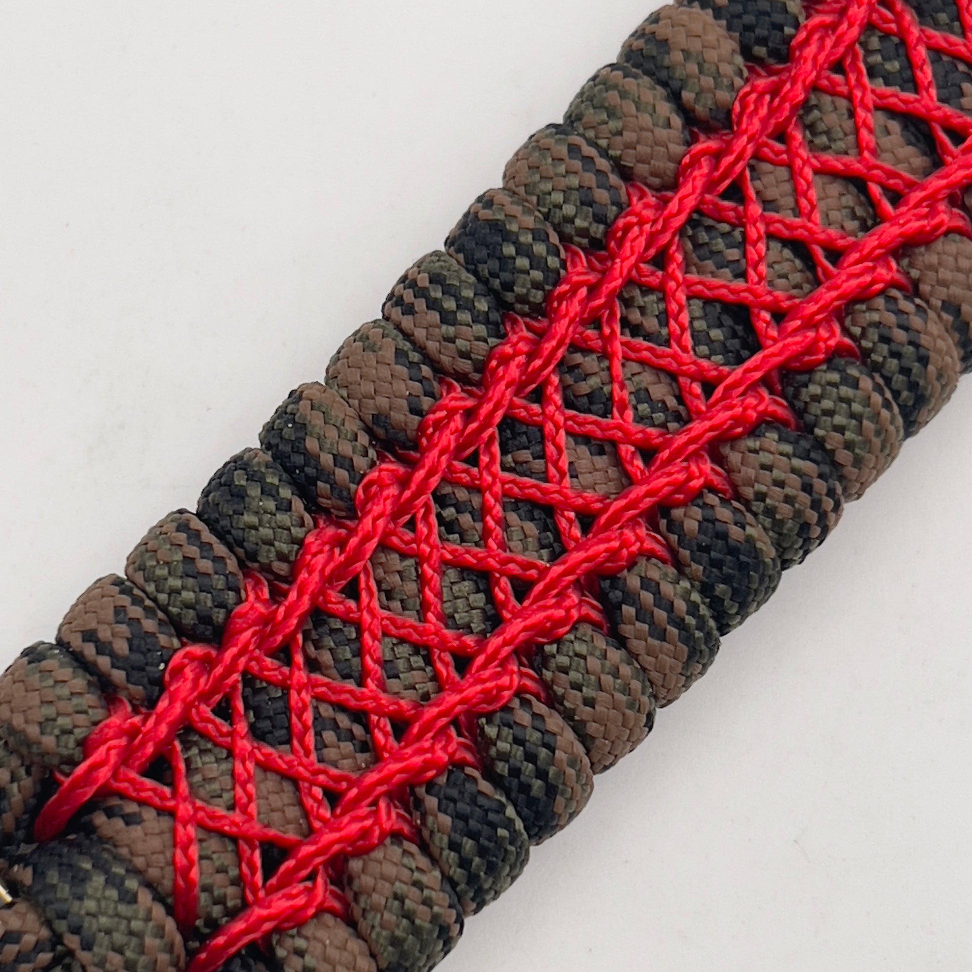Thick, wide, rigid and comfortable braided United States Marine Corps bracelet featuring a 24K gold plated USMC Eagle Globe and Anchor medallion, a gold Cobra style tactical buckle and woven with Woodland Camo 550 paracord and Imperial Red nano and micro cord.