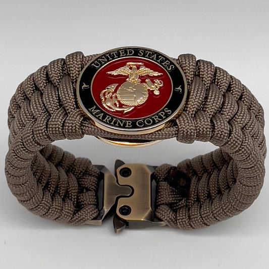 Thick, wide, semi-rigid and comfortable braided United States Marine Corps bracelet featuring a 24K gold plated USMC Eagle Globe and Anchor medallion, a gold Cobra style tactical buckle and woven with tan 550 paracord.