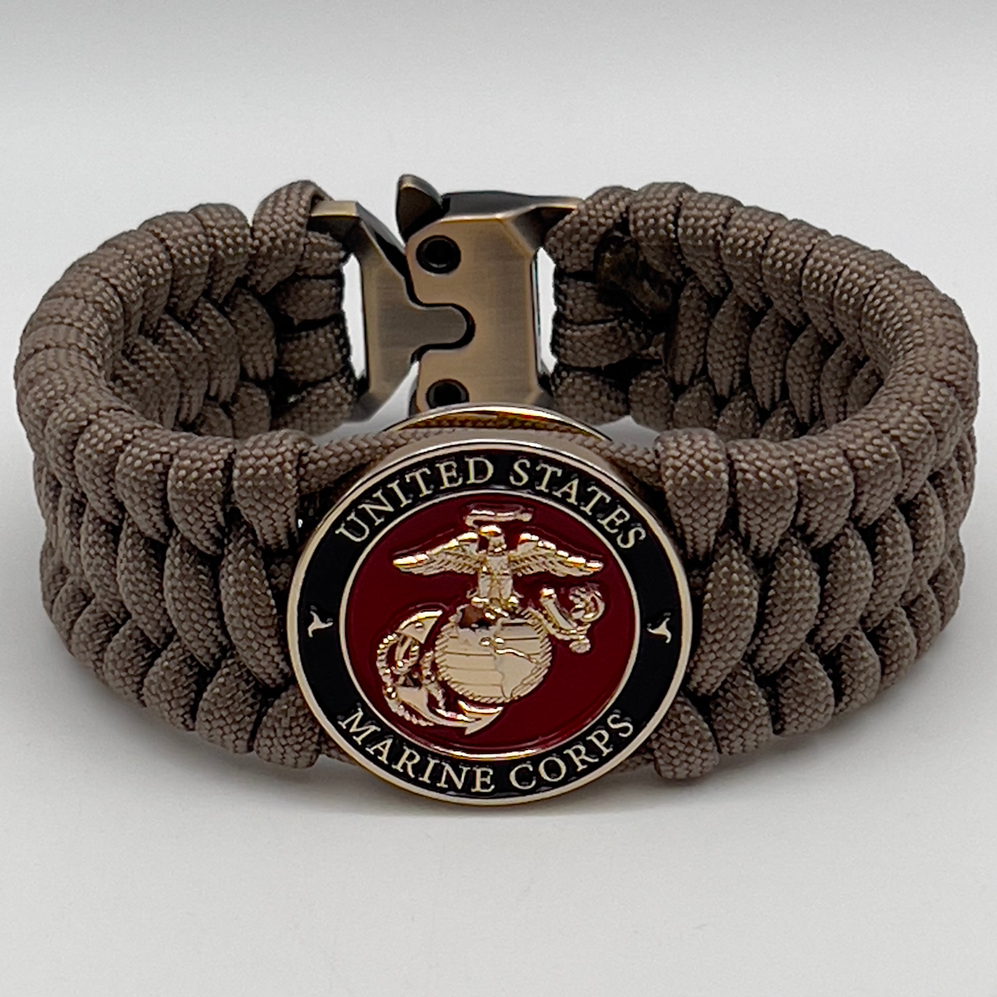 Thick, wide, semi-rigid and comfortable braided United States Marine Corps bracelet featuring a 24K gold plated USMC Eagle Globe and Anchor medallion, a gold Cobra style tactical buckle and woven with tan 550 paracord.