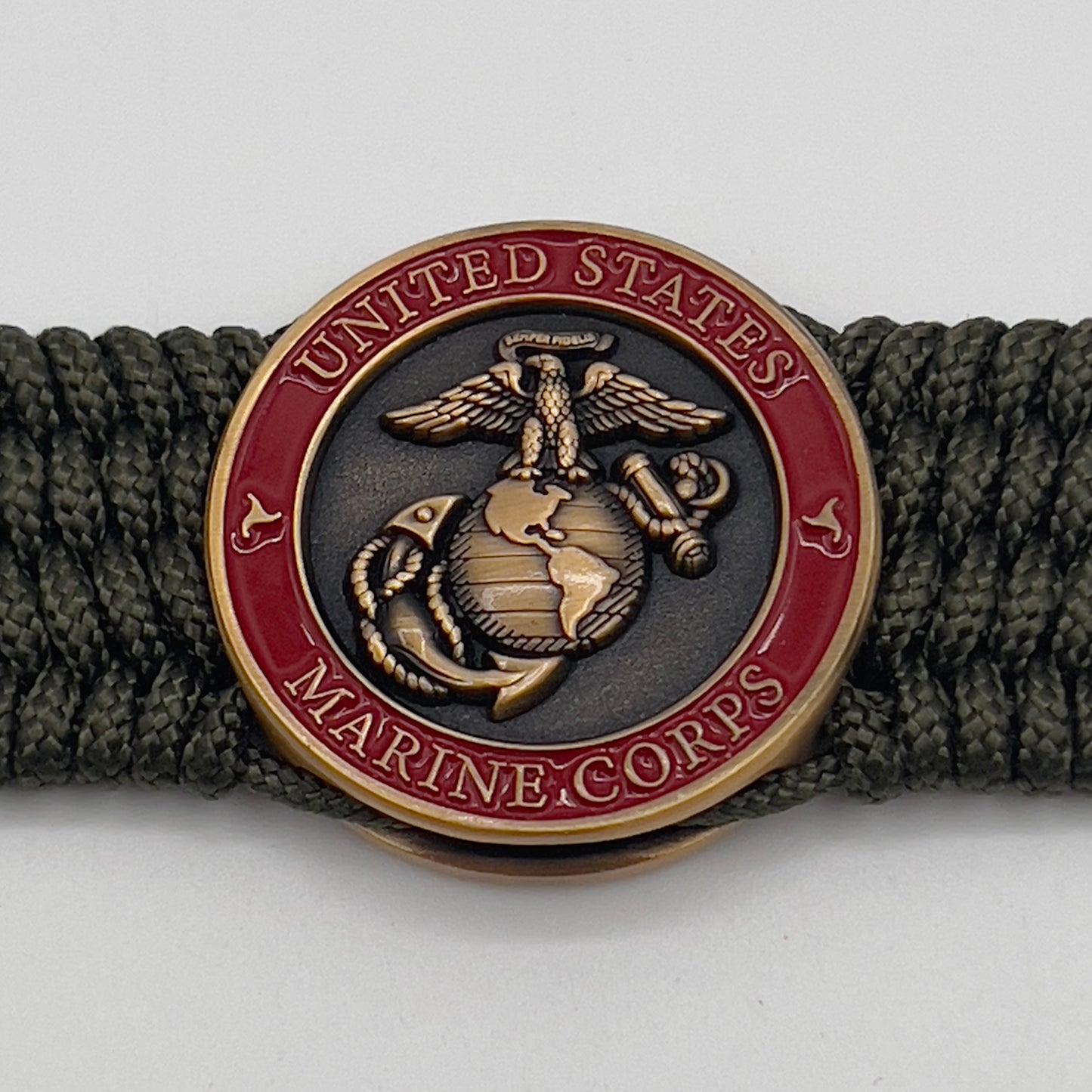Thin, wide, very flexible and comfortable braided United States Marine Corps bracelet featuring a 24K antique gold plated USMC Eagle Globe and Anchor medallion, a gold Cobra style tactical buckle and woven with OIive Drab Type-1 paracord.