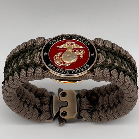 Thick, wide, rigid and comfortable braided United States Marine Corps bracelet featuring a 24K gold plated USMC Eagle Globe and Anchor medallion, a gold Cobra style tactical buckle and woven with tan 550 paracord and olive drab nano and micro cord.