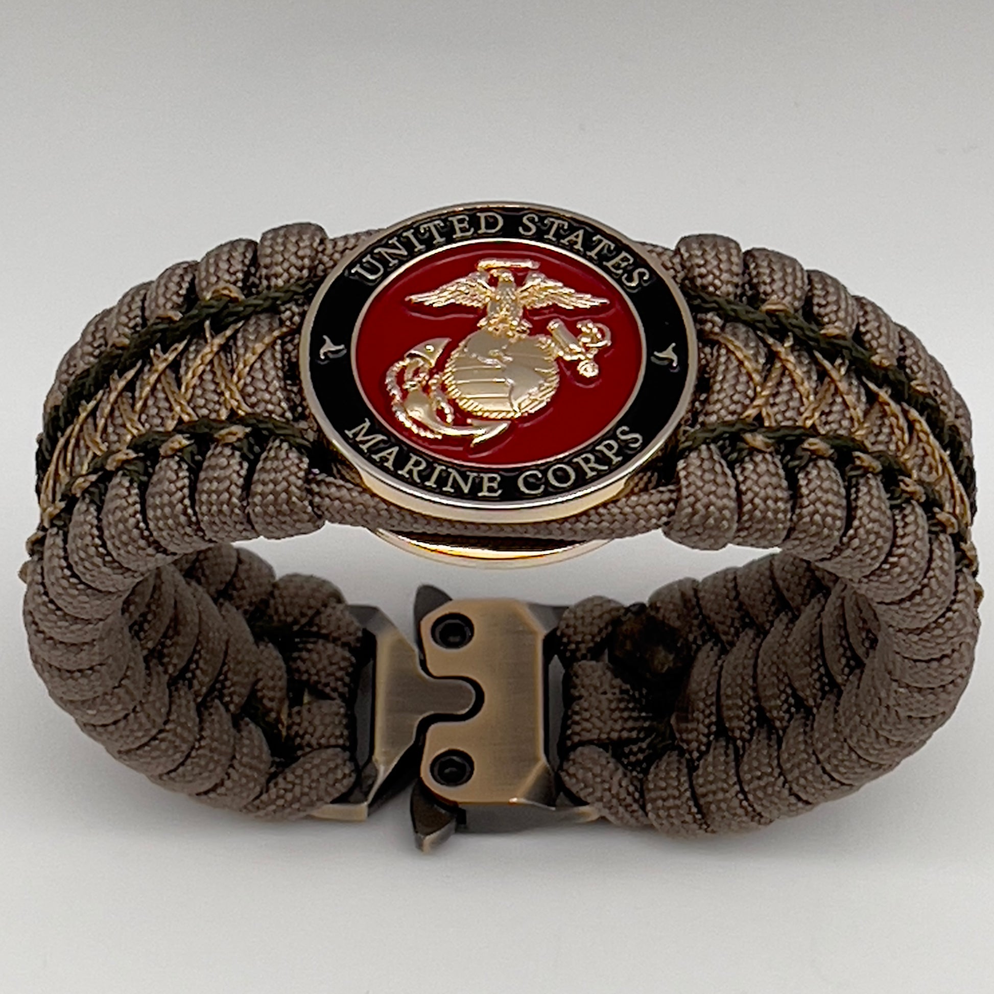 Thick, wide, rigid and comfortable braided United States Marine Corps bracelet featuring a 24K gold plated USMC Eagle Globe and Anchor medallion, a gold Cobra style tactical buckle and woven with tan 550 paracord and olive drab micro and tan nano cord.