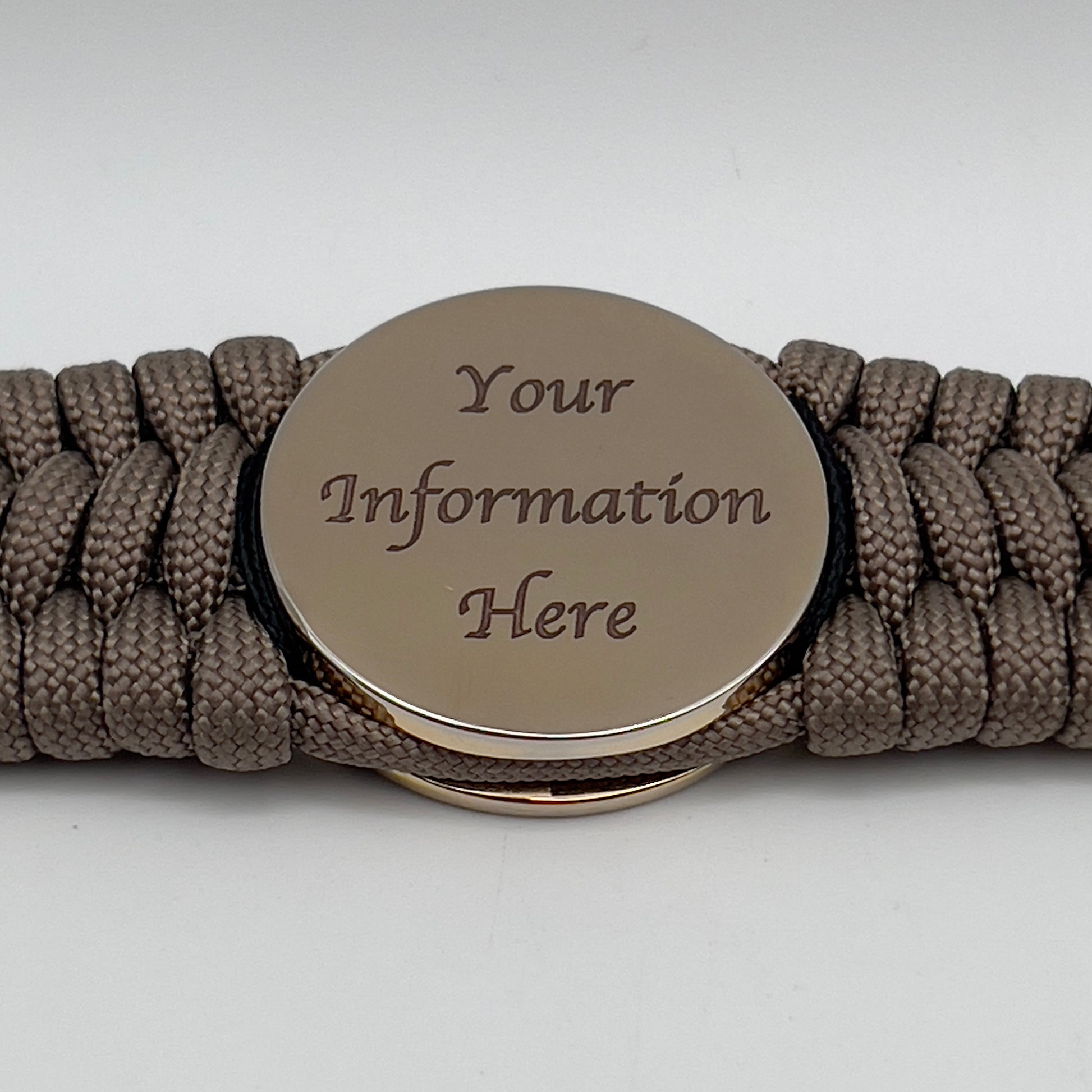 Thick, wide, rigid and comfortable braided United States Marine Corps bracelet featuring a 24K gold plated USMC Eagle Globe and Anchor medallion, a gold Cobra style tactical buckle and woven with tan 550 paracord and black nano and micro cord.