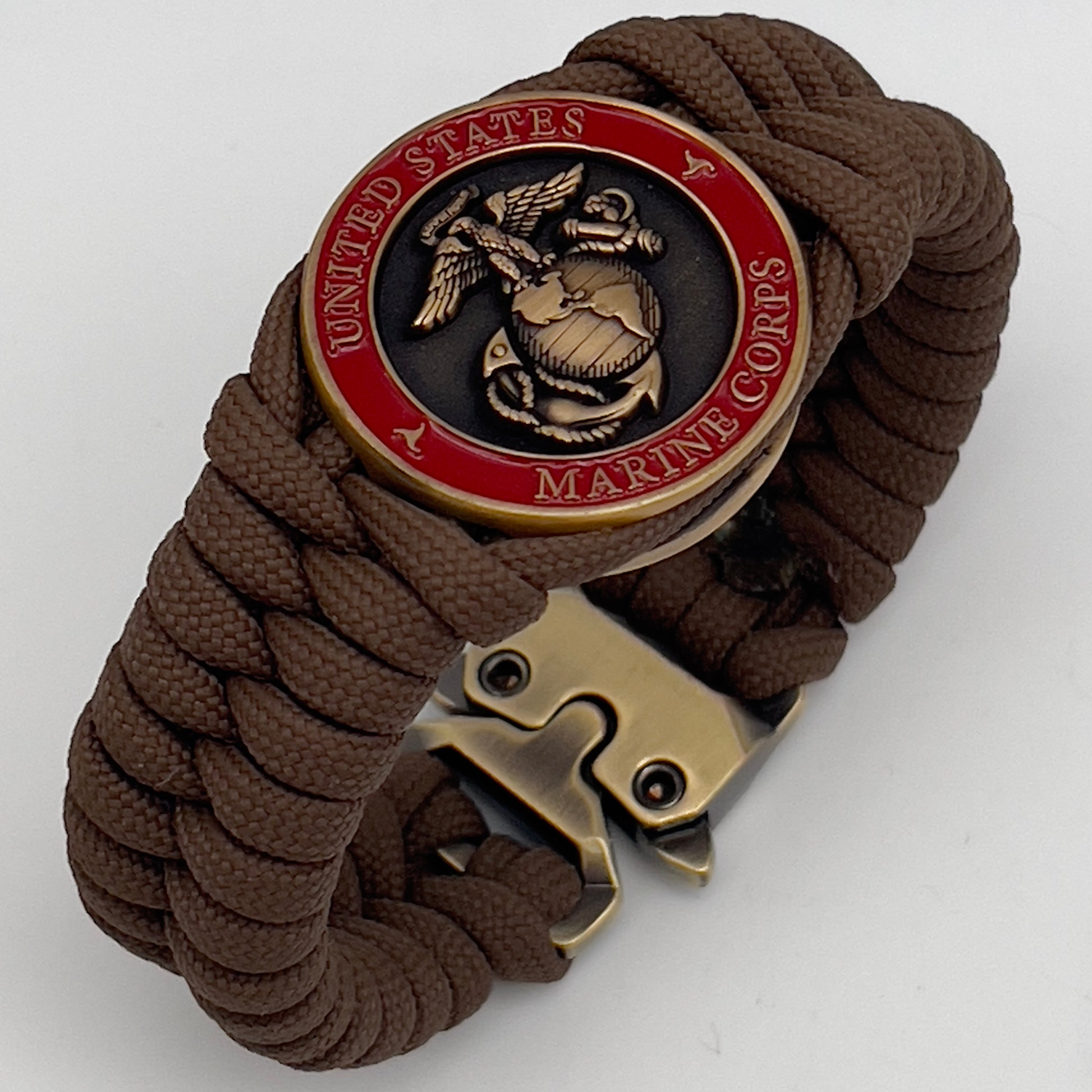 Thick, medium width, semi-rigid and comfortable braided United States Marine Corps bracelet featuring a 24K antique gold plated USMC Eagle Globe and Anchor medallion, a gold Cobra style tactical buckle and woven with Coyote Brown 550 paracord 