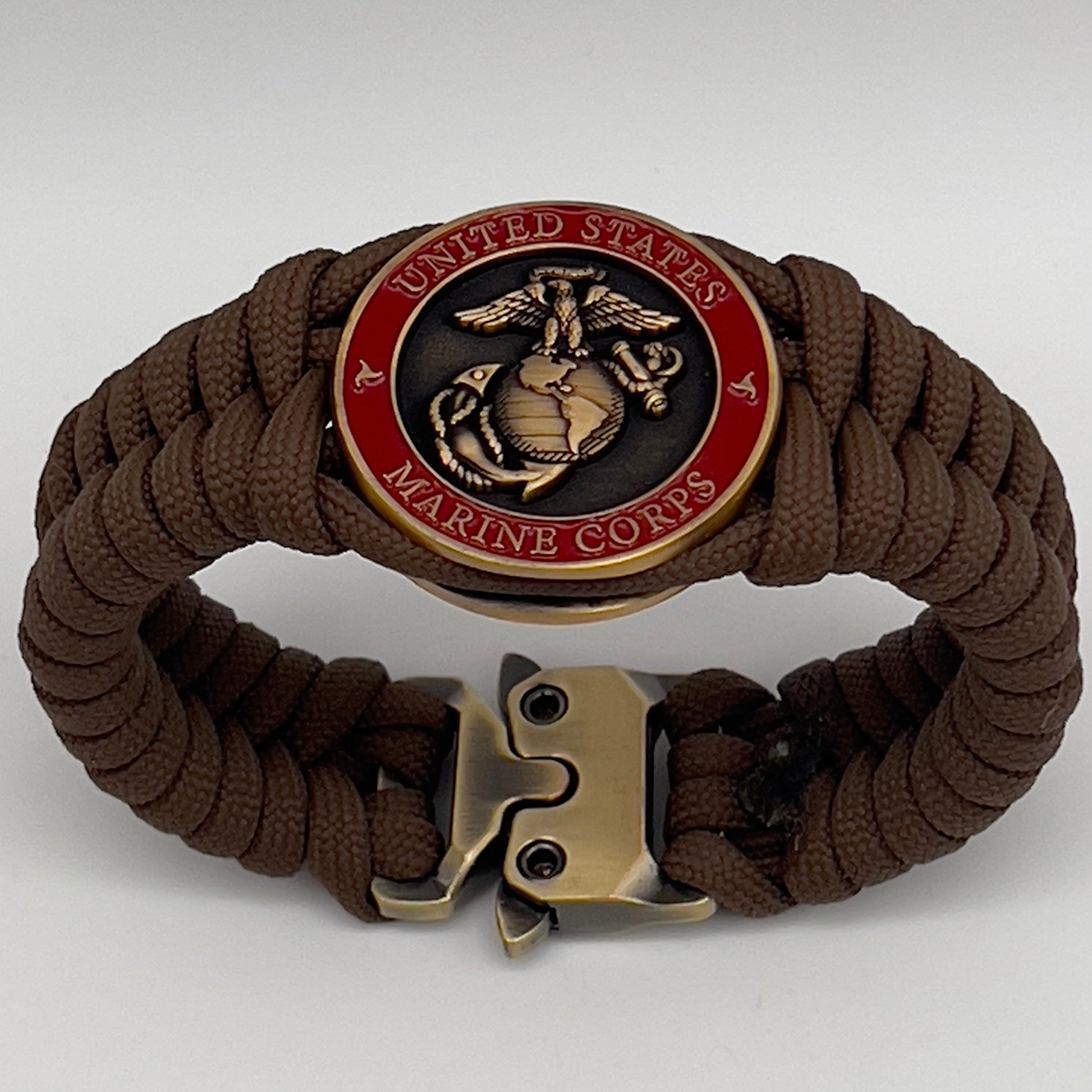 Thick, medium width, semi-rigid and comfortable braided United States Marine Corps bracelet featuring a 24K antique gold plated USMC Eagle Globe and Anchor medallion, a gold Cobra style tactical buckle and woven with Coyote Brown 550 paracord 