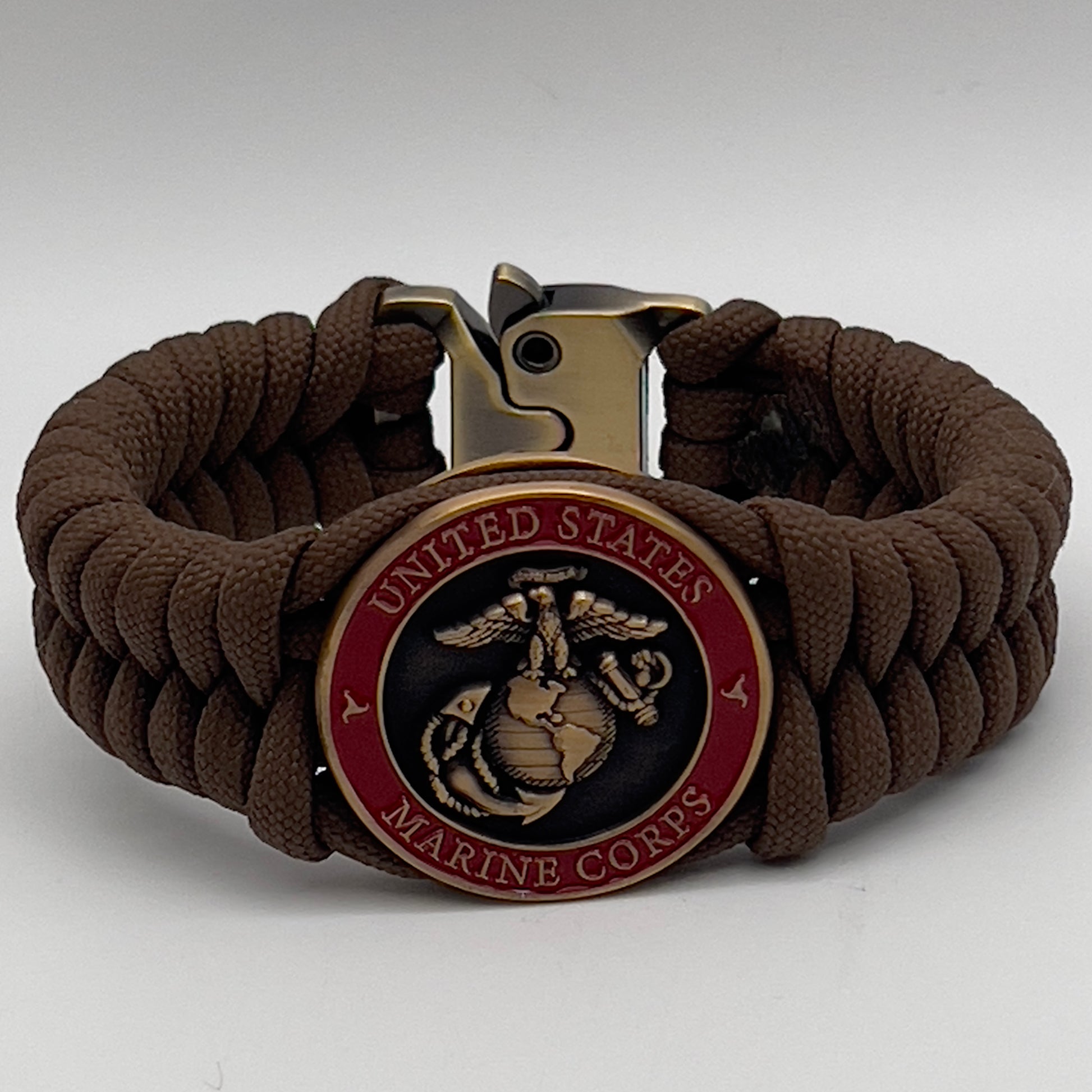 Thick, medium width, semi-rigid and comfortable braided United States Marine Corps bracelet featuring a 24K antique gold plated USMC Eagle Globe and Anchor medallion, a gold Cobra style tactical buckle and woven with Coyote Brown 550 paracord 