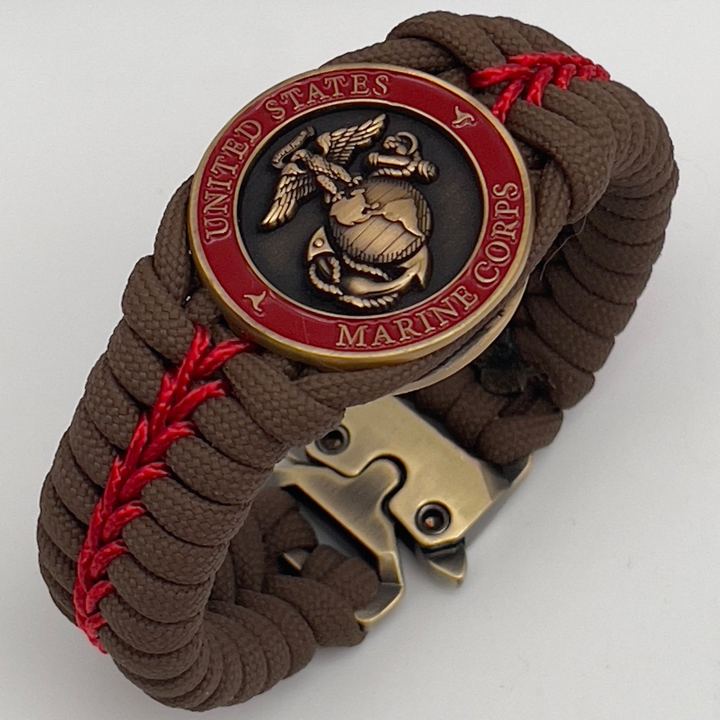 Thick, medium width, semi-rigid and comfortable braided United States Marine Corps bracelet featuring a 24K antique gold plated USMC Eagle Globe and Anchor medallion, a gold Cobra style tactical buckle and woven with Coyote Brown 550 paracord and Imperial Red micro cord.