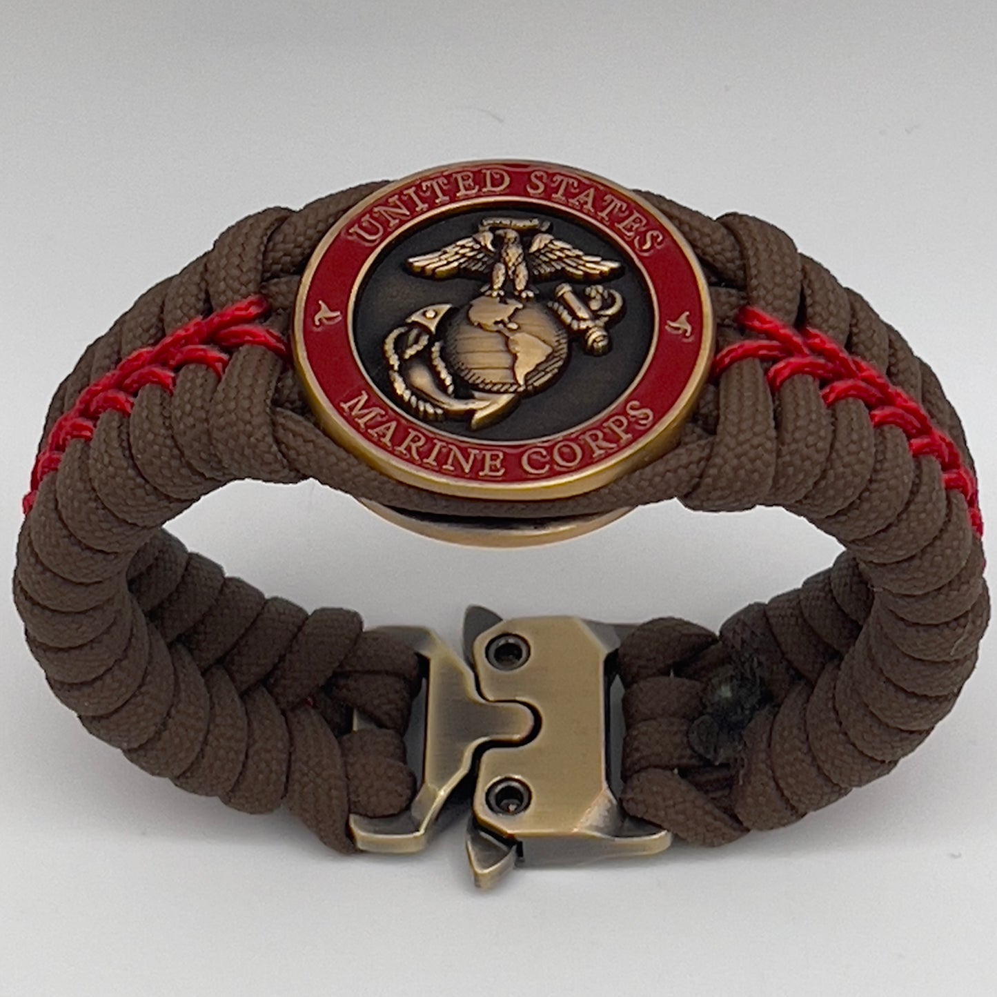 Thick, medium width, semi-rigid and comfortable braided United States Marine Corps bracelet featuring a 24K antique gold plated USMC Eagle Globe and Anchor medallion, a gold Cobra style tactical buckle and woven with Coyote Brown 550 paracord and Imperial Red micro cord.