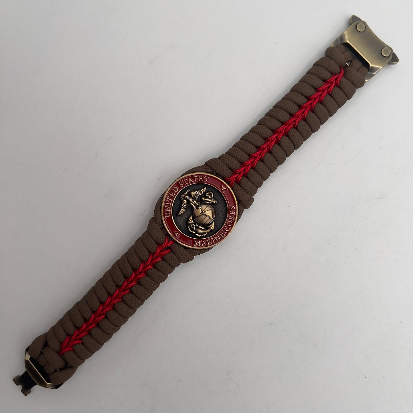 Thick, medium width, semi-rigid and comfortable braided United States Marine Corps bracelet featuring a 24K antique gold plated USMC Eagle Globe and Anchor medallion, a gold Cobra style tactical buckle and woven with Coyote Brown 550 paracord and Imperial Red micro cord.