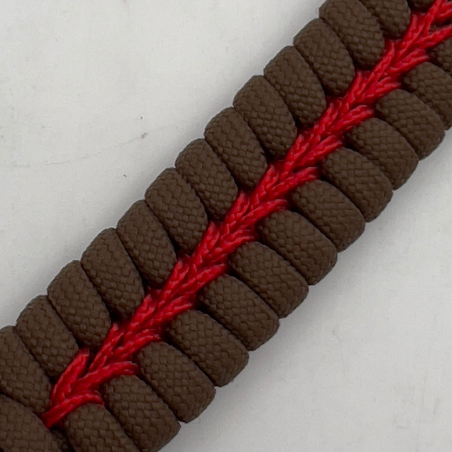 Thick, medium width, semi-rigid and comfortable braided United States Marine Corps bracelet featuring a 24K antique gold plated USMC Eagle Globe and Anchor medallion, a gold Cobra style tactical buckle and woven with Coyote Brown 550 paracord and Imperial Red micro cord.