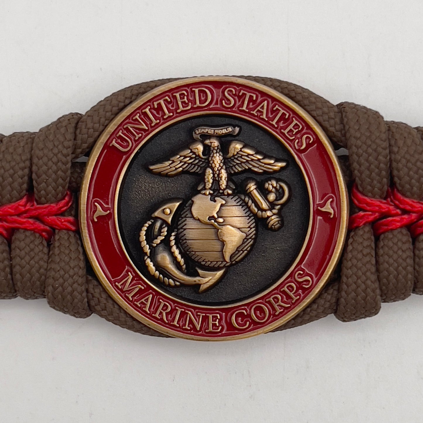 Thick, medium width, semi-rigid and comfortable braided United States Marine Corps bracelet featuring a 24K antique gold plated USMC Eagle Globe and Anchor medallion, a gold Cobra style tactical buckle and woven with Coyote Brown 550 paracord and Imperial Red micro cord.