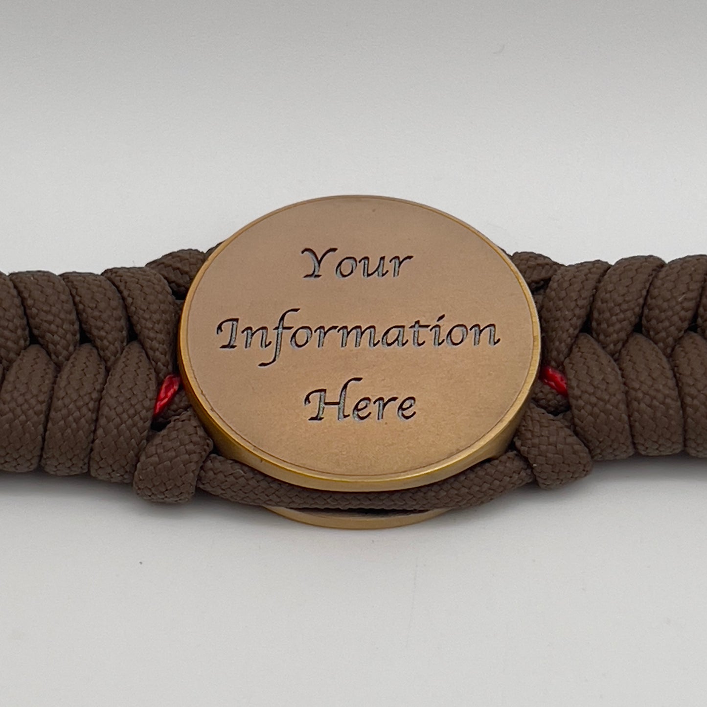 Thick, medium width, semi-rigid and comfortable braided United States Marine Corps bracelet featuring a 24K antique gold plated USMC Eagle Globe and Anchor medallion, a gold Cobra style tactical buckle and woven with Coyote Brown 550 paracord and Imperial Red micro cord.