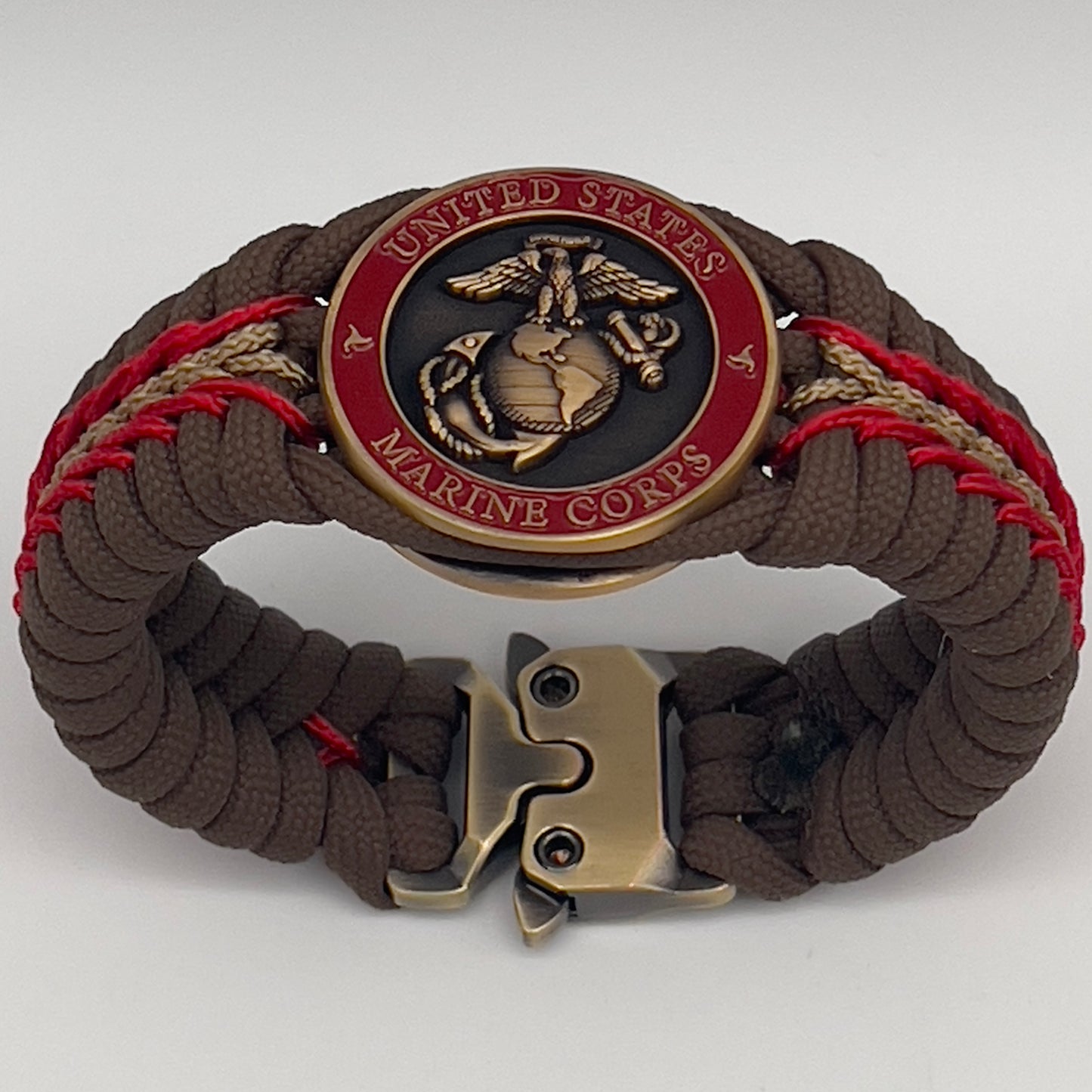 Thick, medium width, rigid and comfortable braided United States Marine Corps bracelet featuring a 24K antique gold plated USMC Eagle Globe and Anchor medallion, a gold Cobra style tactical buckle and woven with Coyote Brown 550 paracord and Imperial Red and Gold micro cord.