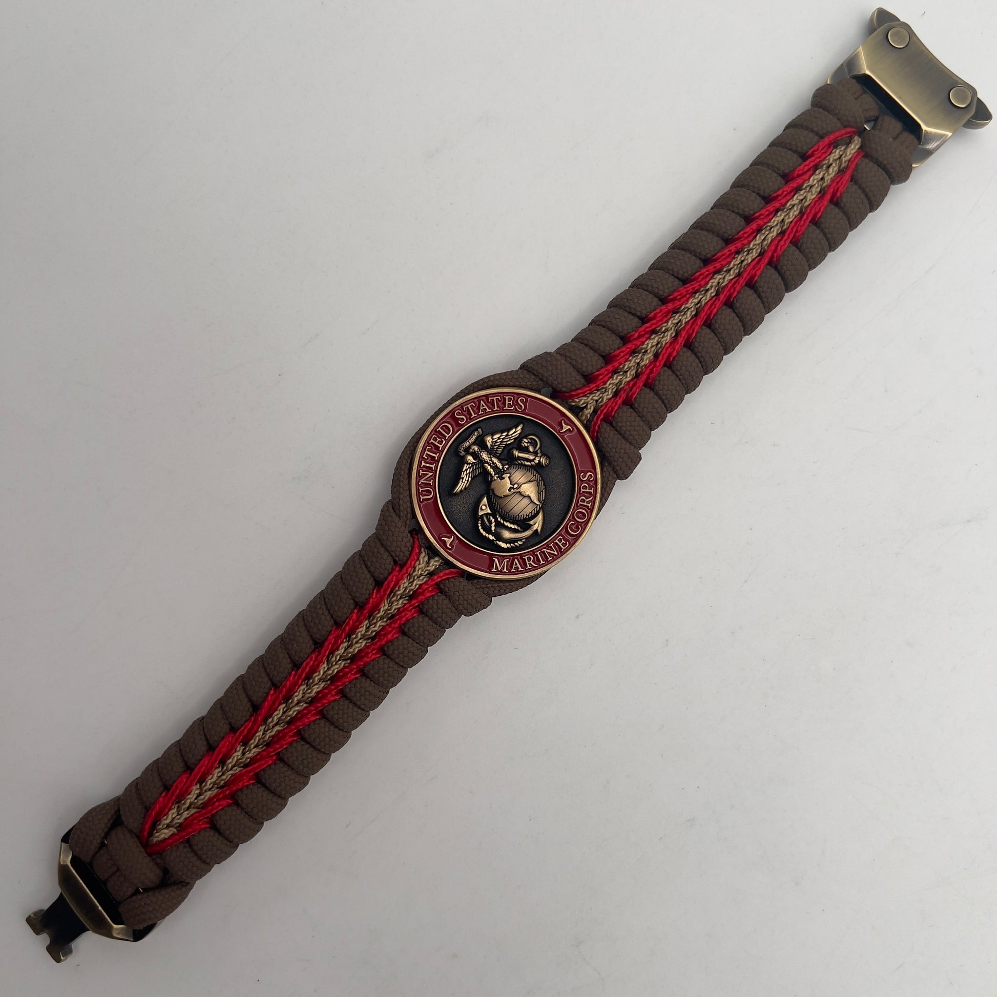 Thick, medium width, rigid and comfortable braided United States Marine Corps bracelet featuring a 24K antique gold plated USMC Eagle Globe and Anchor medallion, a gold Cobra style tactical buckle and woven with Coyote Brown 550 paracord and Imperial Red and Gold micro cord.
