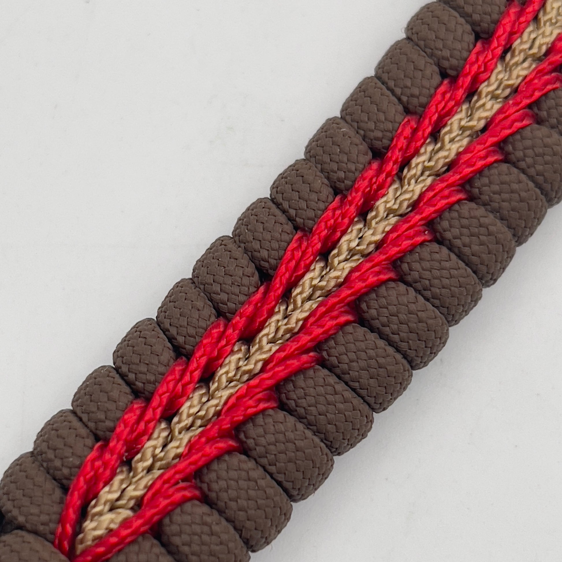 Thick, medium width, rigid and comfortable braided United States Marine Corps bracelet featuring a 24K antique gold plated USMC Eagle Globe and Anchor medallion, a gold Cobra style tactical buckle and woven with Coyote Brown 550 paracord and Imperial Red and Gold micro cord.