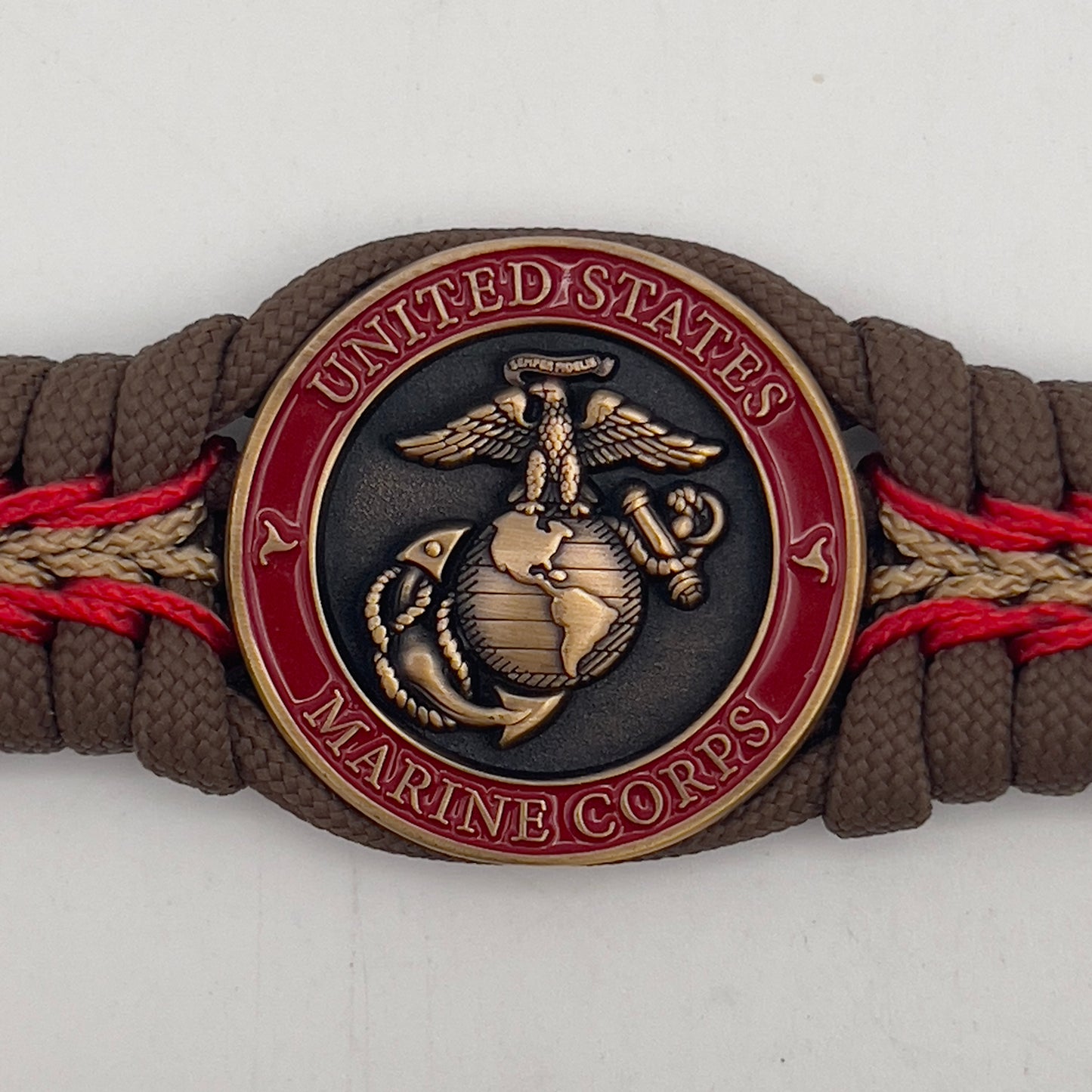 Thick, medium width, rigid and comfortable braided United States Marine Corps bracelet featuring a 24K antique gold plated USMC Eagle Globe and Anchor medallion, a gold Cobra style tactical buckle and woven with Coyote Brown 550 paracord and Imperial Red and Gold micro cord.