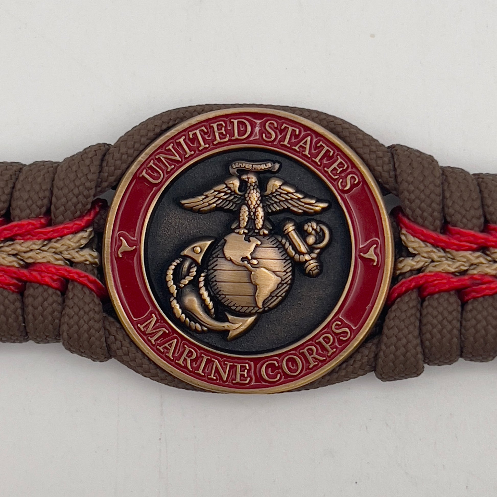 Thick, medium width, rigid and comfortable braided United States Marine Corps bracelet featuring a 24K antique gold plated USMC Eagle Globe and Anchor medallion, a gold Cobra style tactical buckle and woven with Coyote Brown 550 paracord and Imperial Red and Gold micro cord.
