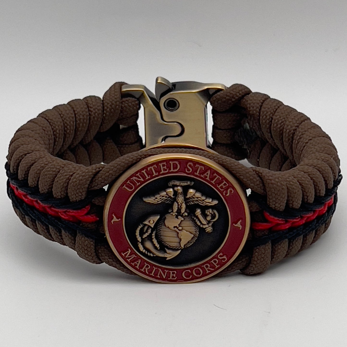 Thick, medium width, rigid and comfortable braided United States Marine Corps bracelet featuring a 24K antique gold plated USMC Eagle Globe and Anchor medallion, a gold Cobra style tactical buckle and woven with Coyote Brown 550 paracord and Imperial Red and Black micro cord.