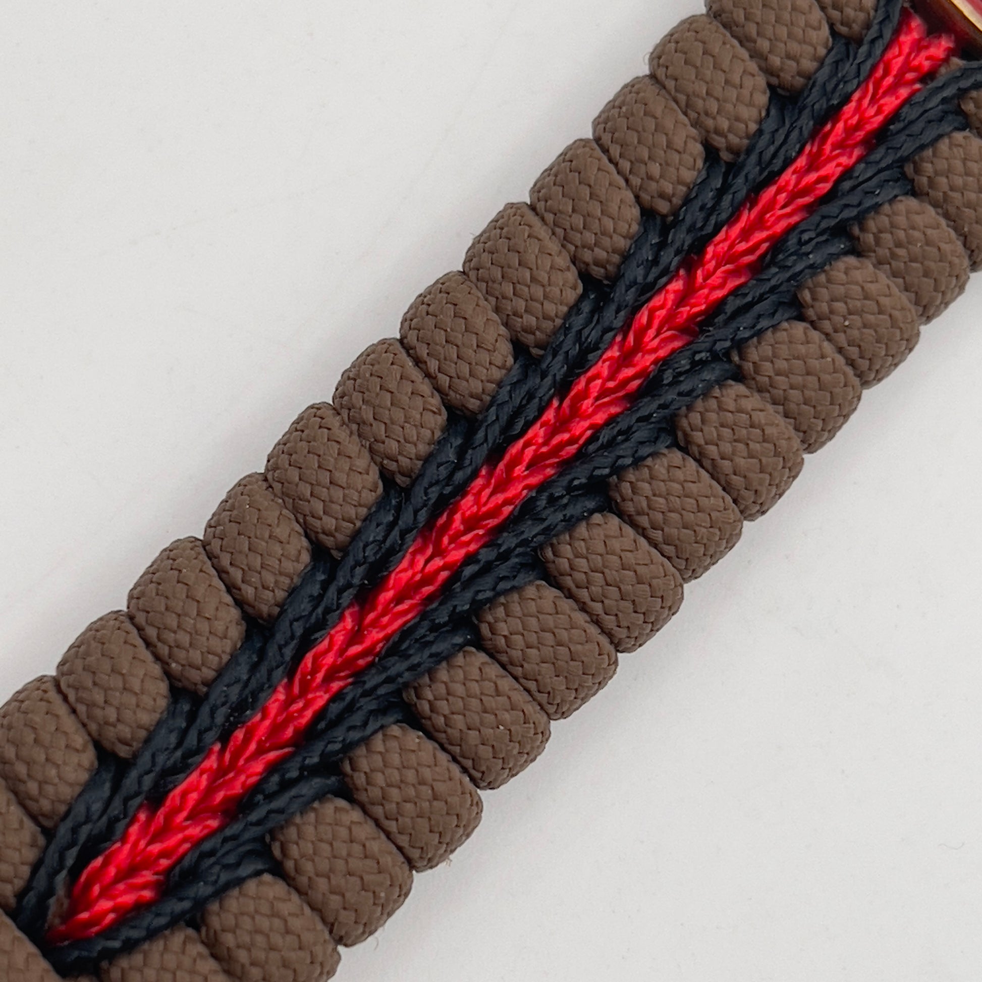 Thick, medium width, rigid and comfortable braided United States Marine Corps bracelet featuring a 24K antique gold plated USMC Eagle Globe and Anchor medallion, a gold Cobra style tactical buckle and woven with Coyote Brown 550 paracord and Imperial Red and Black micro cord.