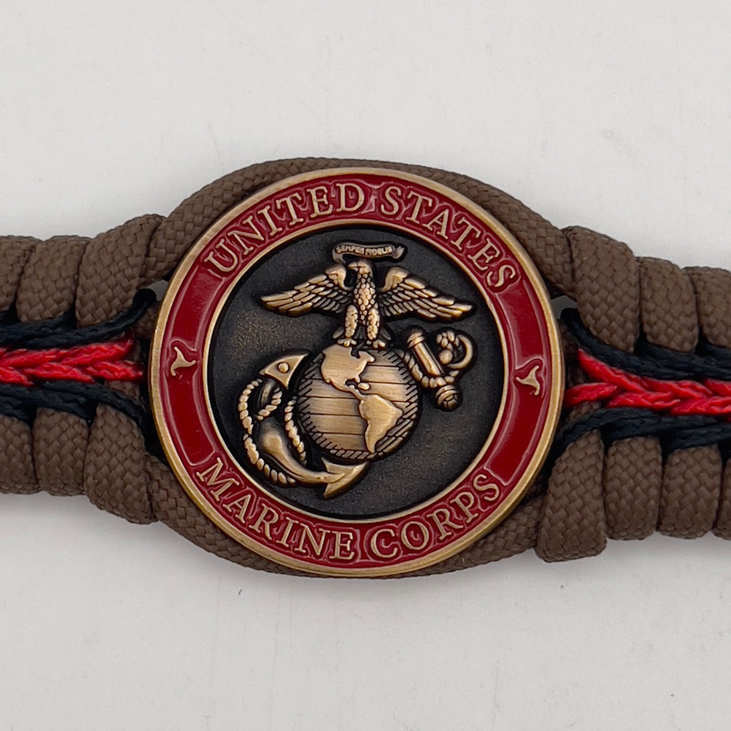 Thick, medium width, rigid and comfortable braided United States Marine Corps bracelet featuring a 24K antique gold plated USMC Eagle Globe and Anchor medallion, a gold Cobra style tactical buckle and woven with Coyote Brown 550 paracord and Imperial Red and Black micro cord.