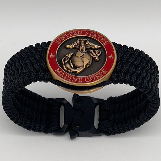 Thin, medium wide, very thin and flexible and comfortable braided United States Marine Corps bracelet featuring a 24K antique gold plated USMC Eagle Globe and Anchor medallion, a black Cobra style tactical buckle and woven with black Type-1 paracord.