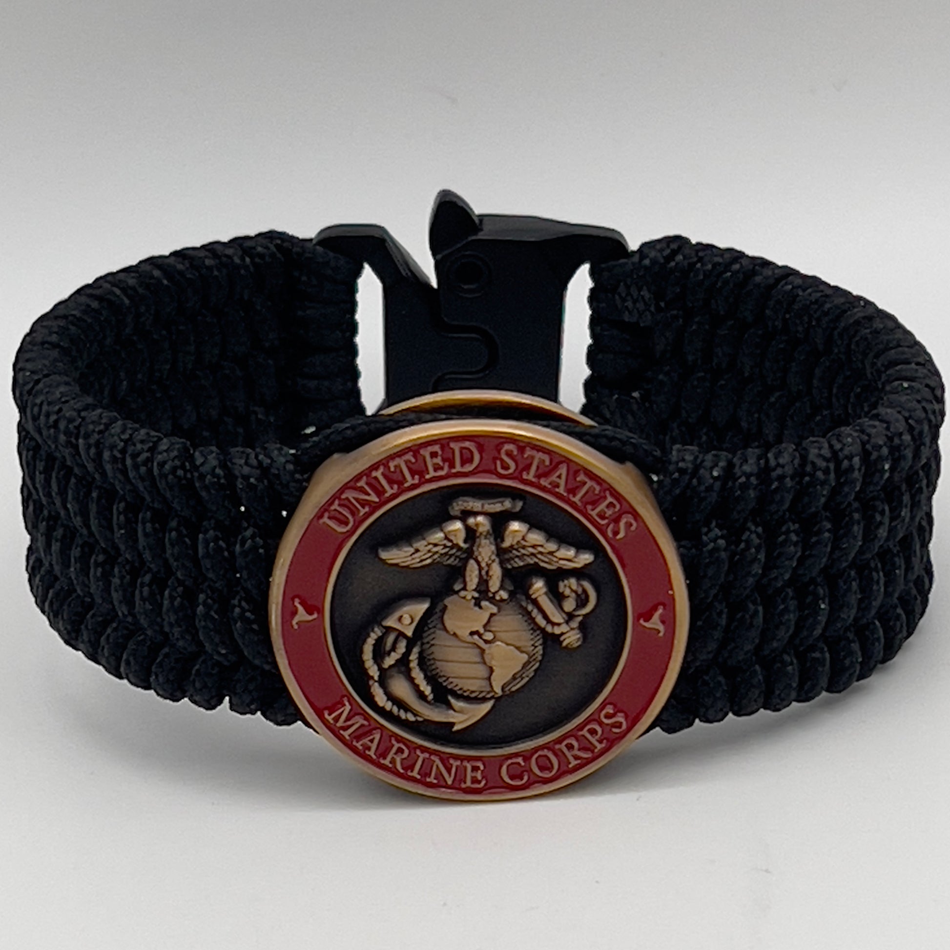 Thin, medium wide, very thin and flexible and comfortable braided United States Marine Corps bracelet featuring a 24K antique gold plated USMC Eagle Globe and Anchor medallion, a black Cobra style tactical buckle and woven with black Type-1 paracord.