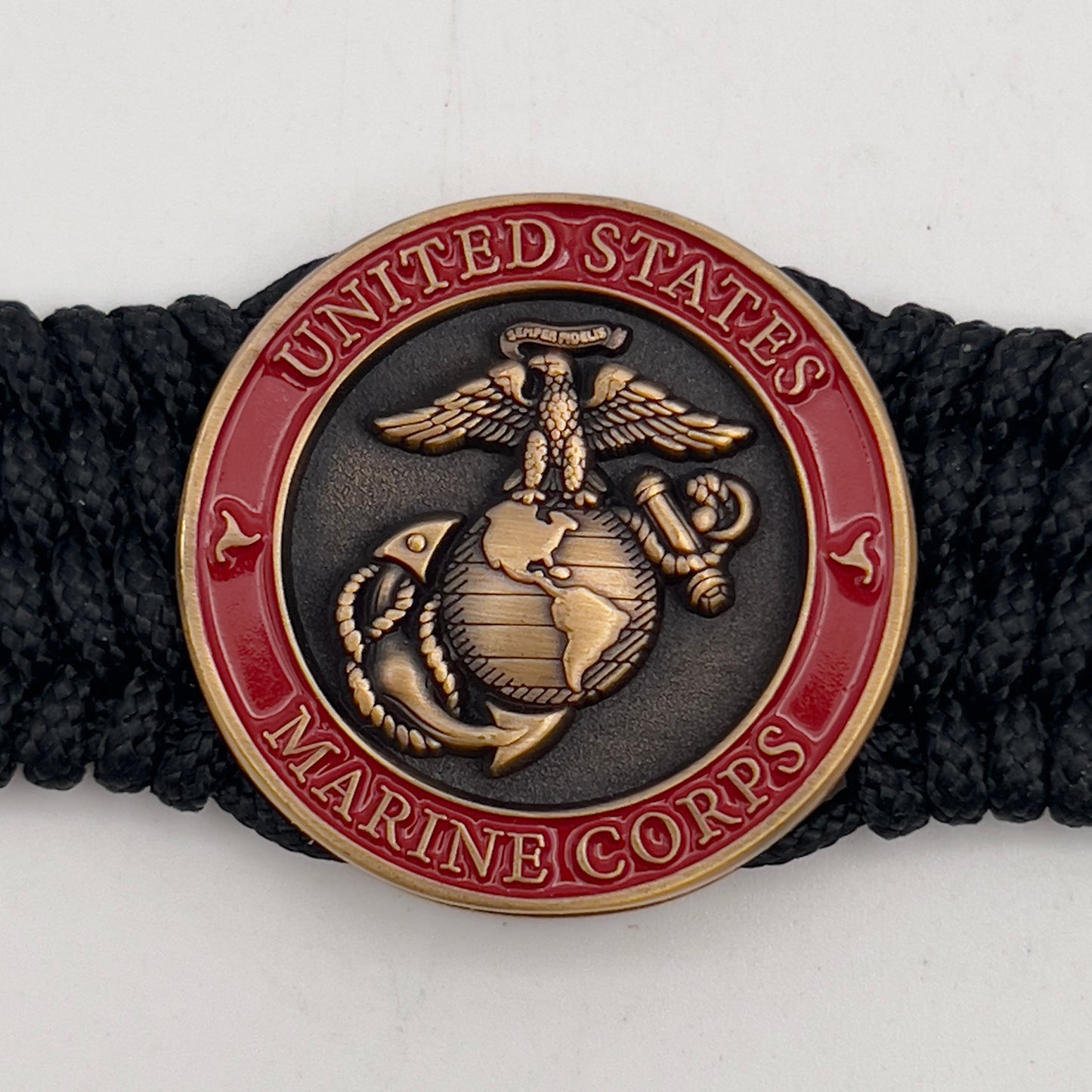 Thin, medium wide, very thin and flexible and comfortable braided United States Marine Corps bracelet featuring a 24K antique gold plated USMC Eagle Globe and Anchor medallion, a black Cobra style tactical buckle and woven with black Type-1 paracord.